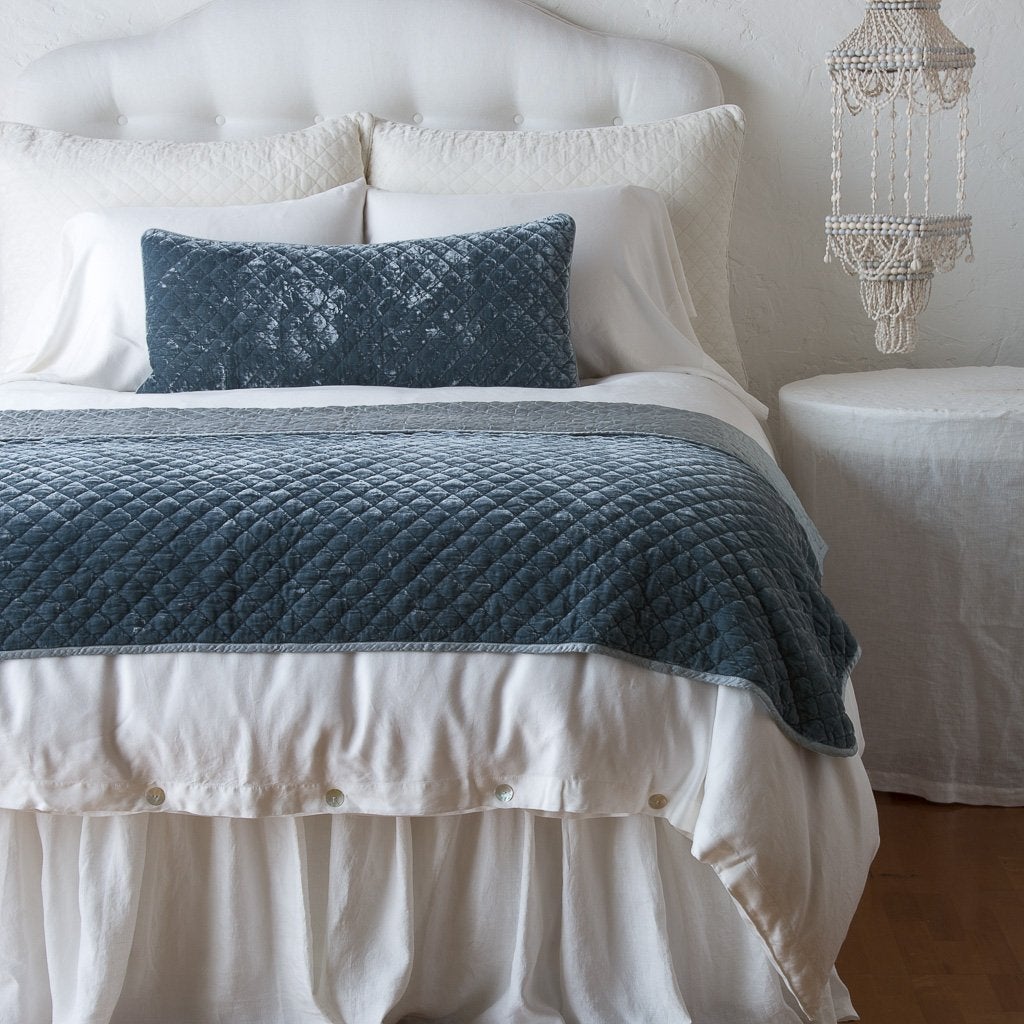 Mineral: 16x36 pillow and matching throw blanket on a white, neatly made bed - end of bed view.