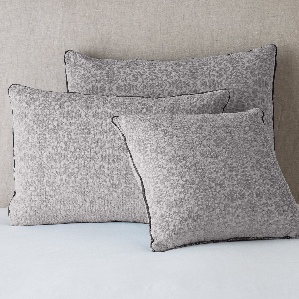 Fog: Cotton chenille jacquard shams leaning upright against a neutral headboard.