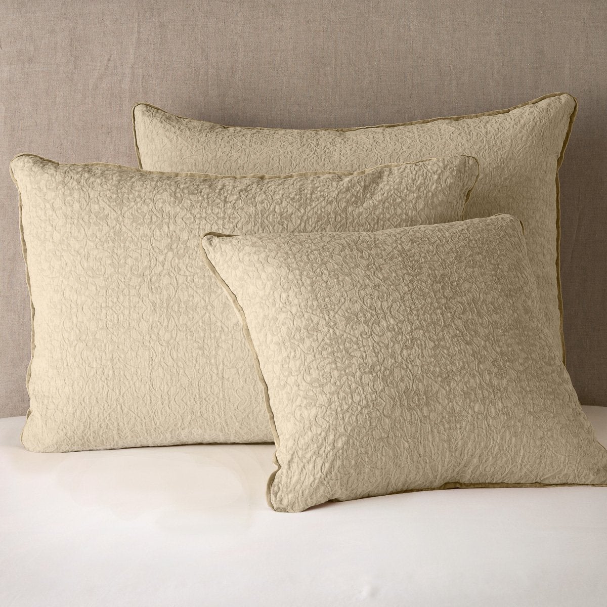Honeycomb: Cotton chenille jacquard shams leaning upright against a neutral headboard.