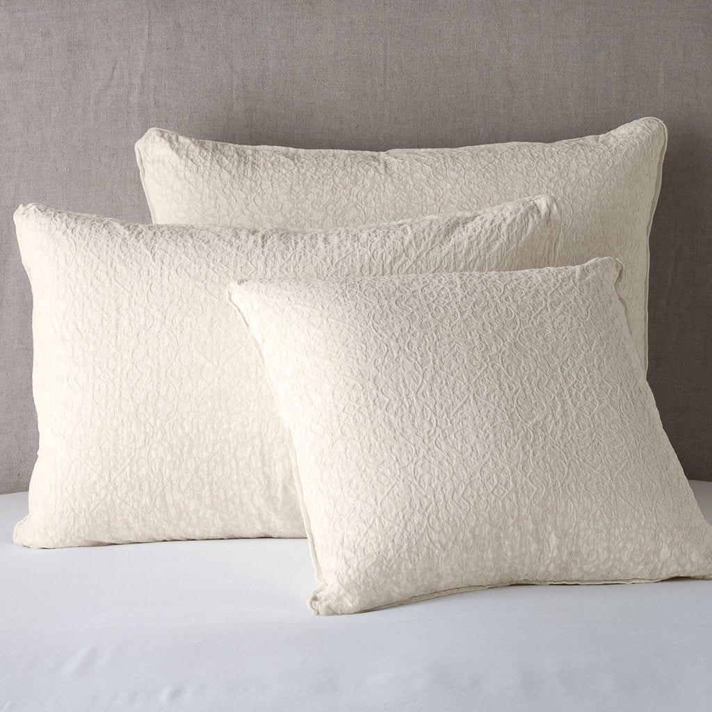 Parchment: Cotton chenille jacquard shams leaning upright against a neutral headboard.