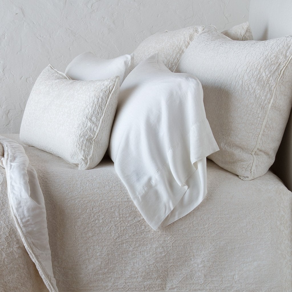 : Vienna shams with matching coverlet and lumbar pillow, and on-tone sleeping pillow - winter white, cropped side view.