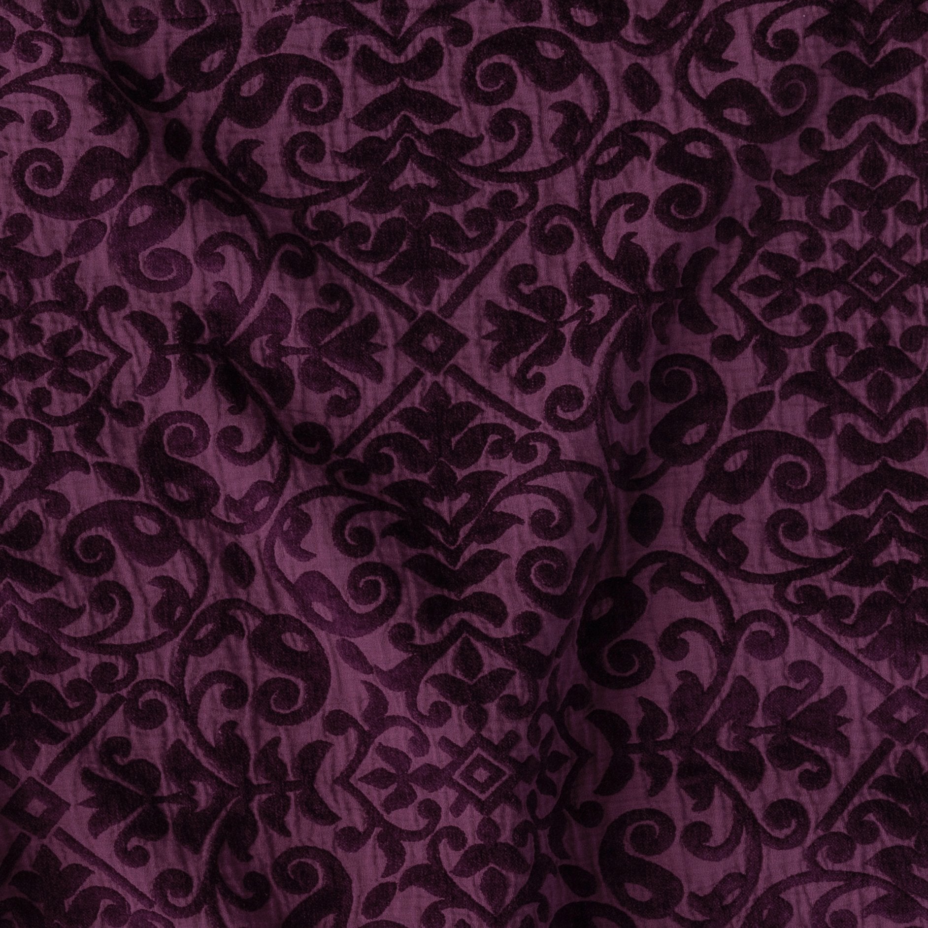 Fig: A close up of Vienna cotton chenille jacquard in fig, a richly saturated purple-garnet.
