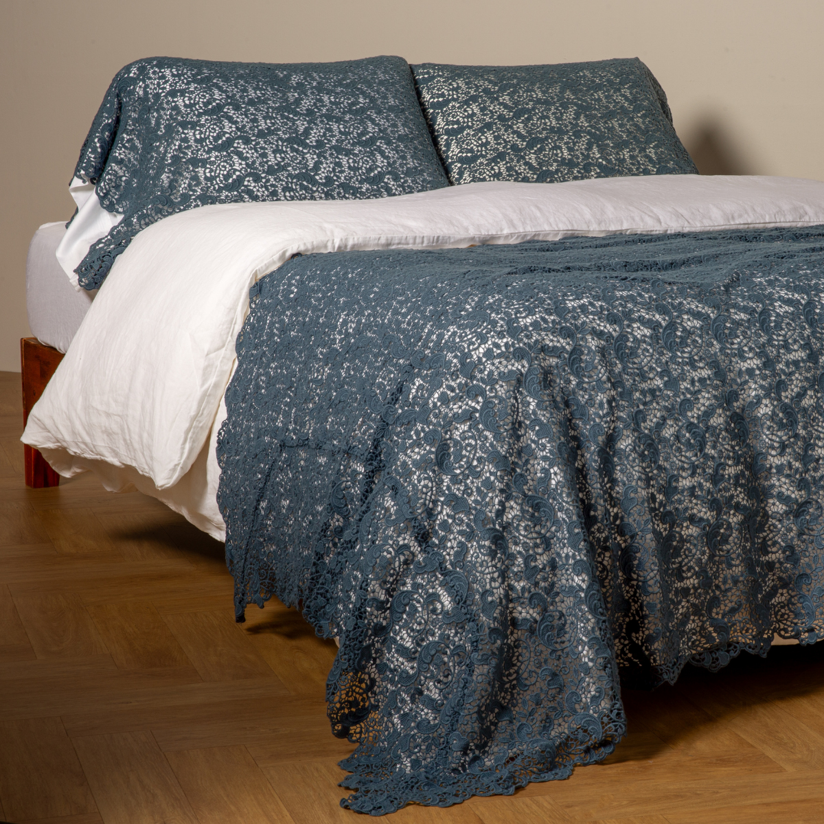 Midnight: cotton lace bed scarf draped across the foot of a bed dressed in linen sheets and duvet cover in winter white -  shown with matching lace pillowcase covers over a linen liner in winter white. 