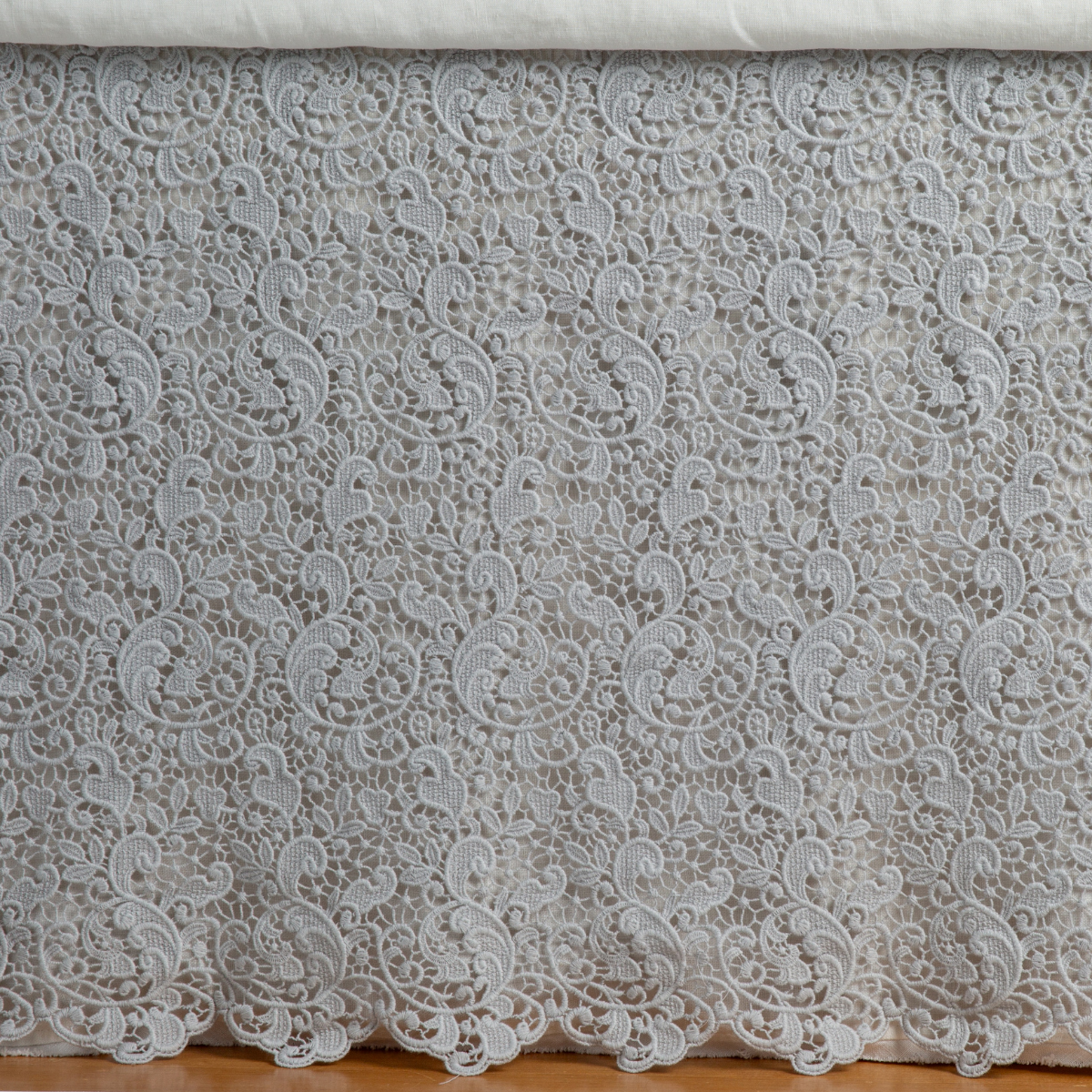 Cloud: a close up of a cotton lace bed skirt layered over a winter white bed skirt - shot straight at the bed skirt. 