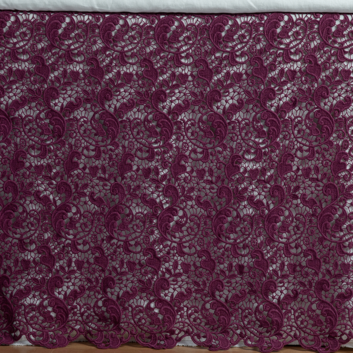 Fig: a close up of a cotton lace bed skirt layered over a winter white bed skirt - shot straight at the bed skirt. 