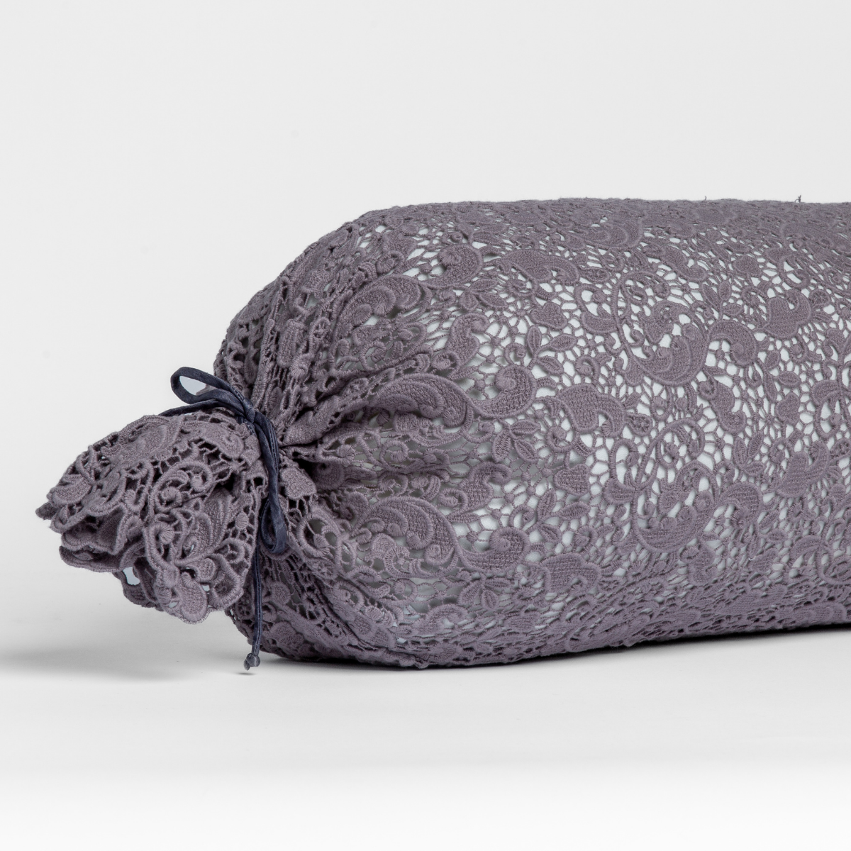 French Lavender: one end of a lace boslter cover on a winter white liner against a white background. 