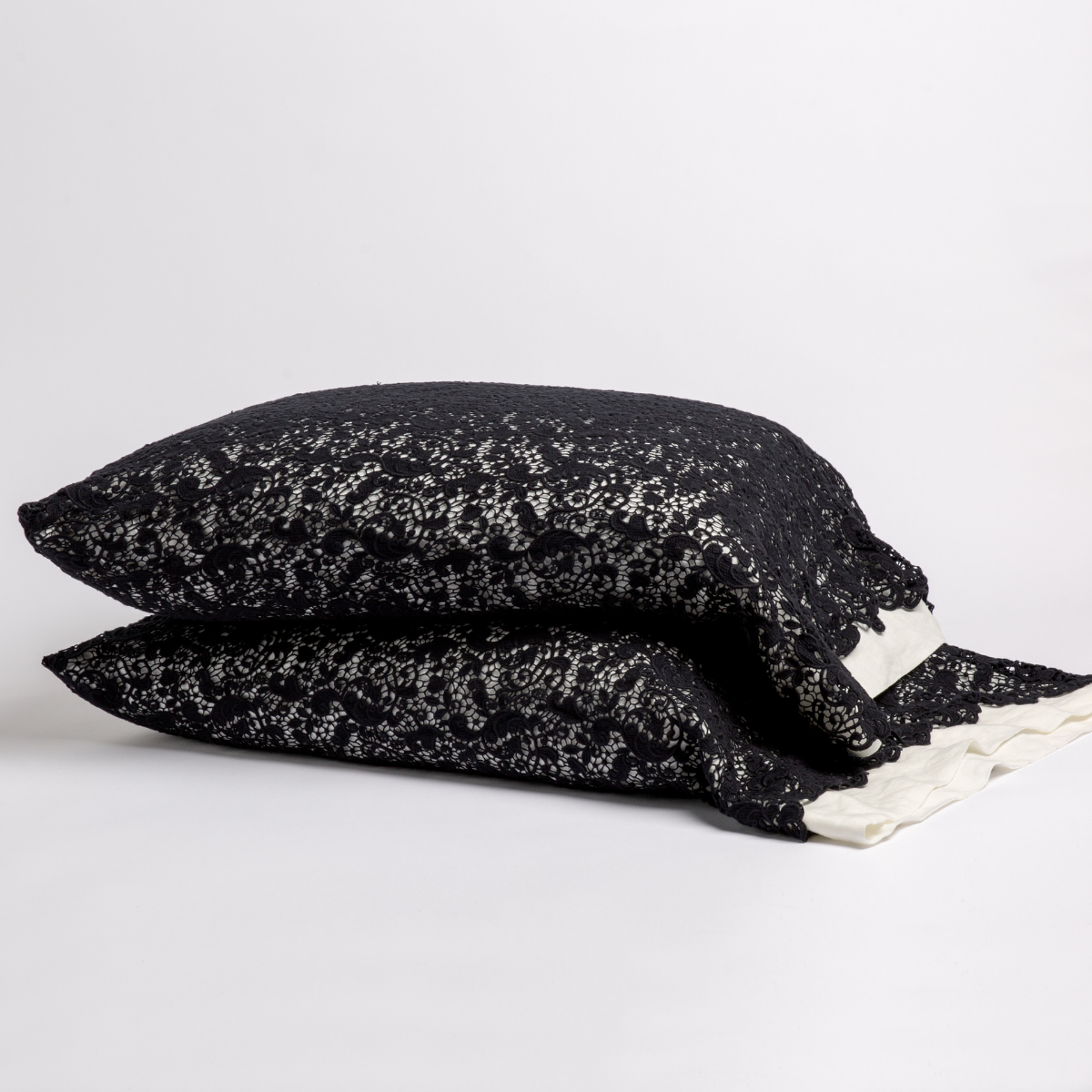 Corvino: a pair of stacked cotton lace pillowcase covers on winter white liners against a white background. 
