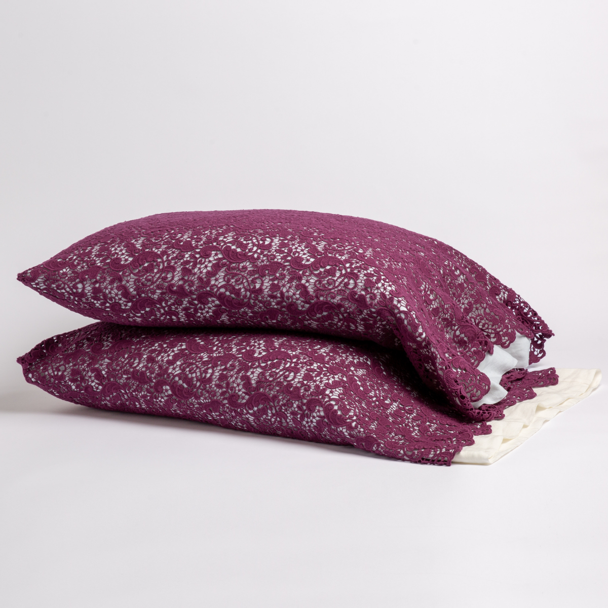 Fig: a pair of stacked cotton lace pillowcase covers on winter white liners against a white background. 