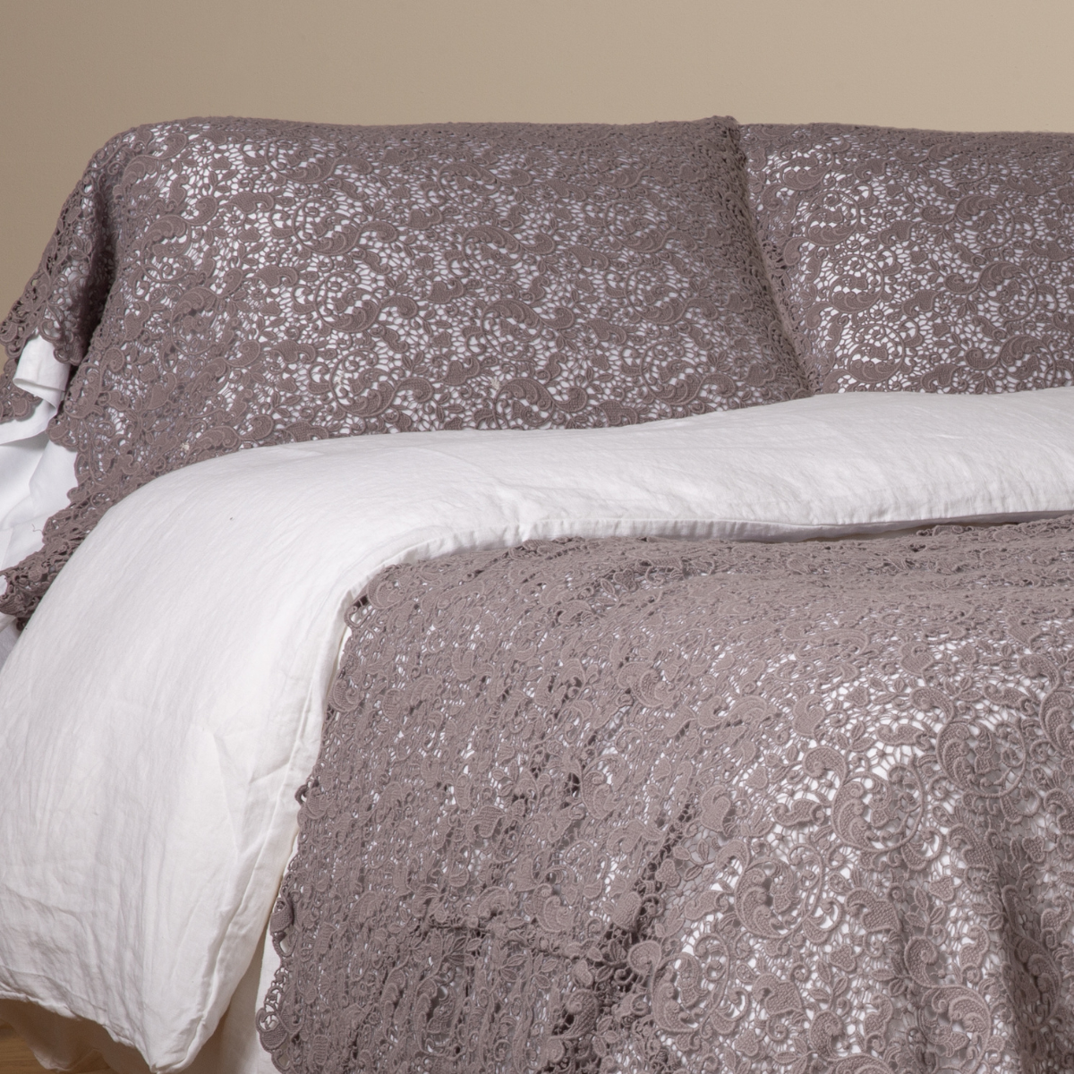French Lavender: a pair of cotton lace pillowcase covers on winter white liners shown on a bed dressed in winter white linen with a matching cotton lace bed scarf. 