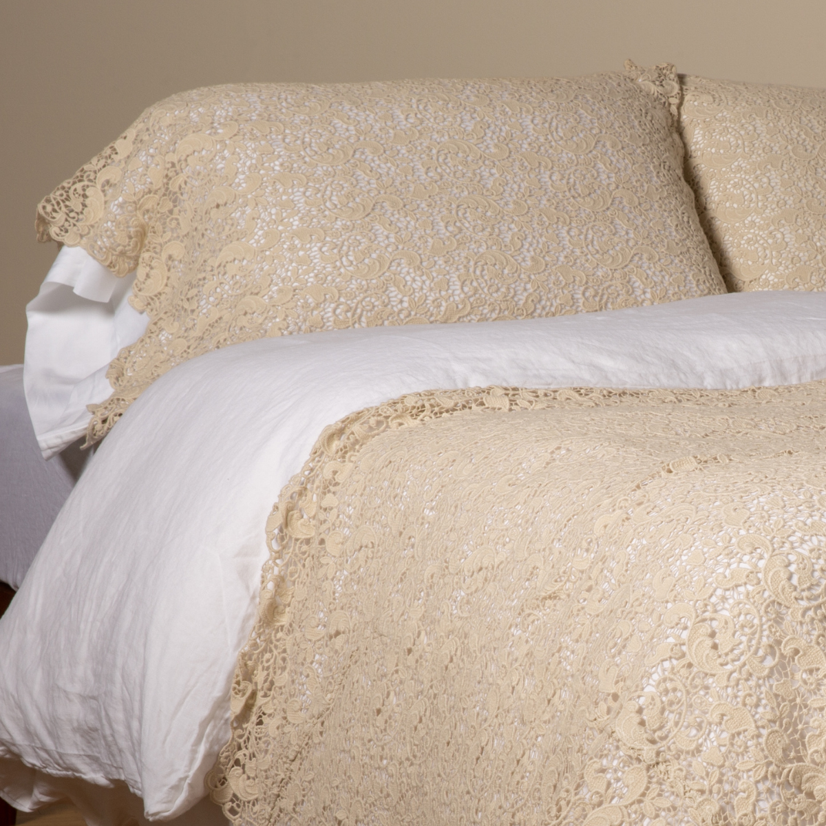 Parchment: a pair of cotton lace pillowcase covers on winter white liners shown on a bed dressed in winter white linen with a matching cotton lace bed scarf. 