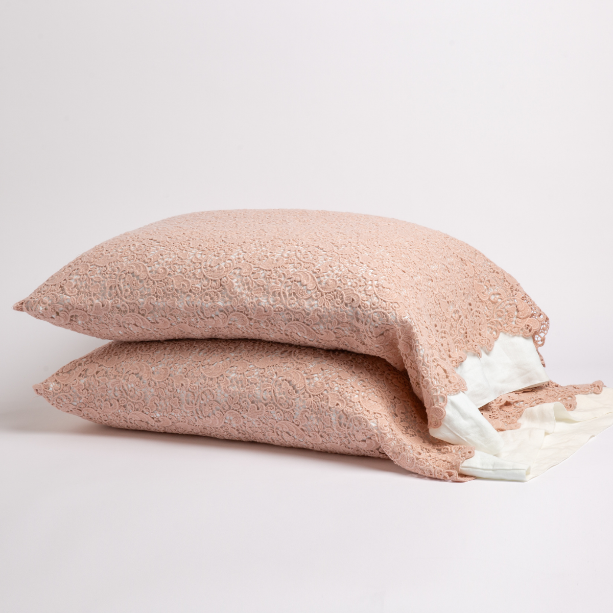 Rouge: a pair of stacked cotton lace pillowcase covers on winter white liners against a white background. 