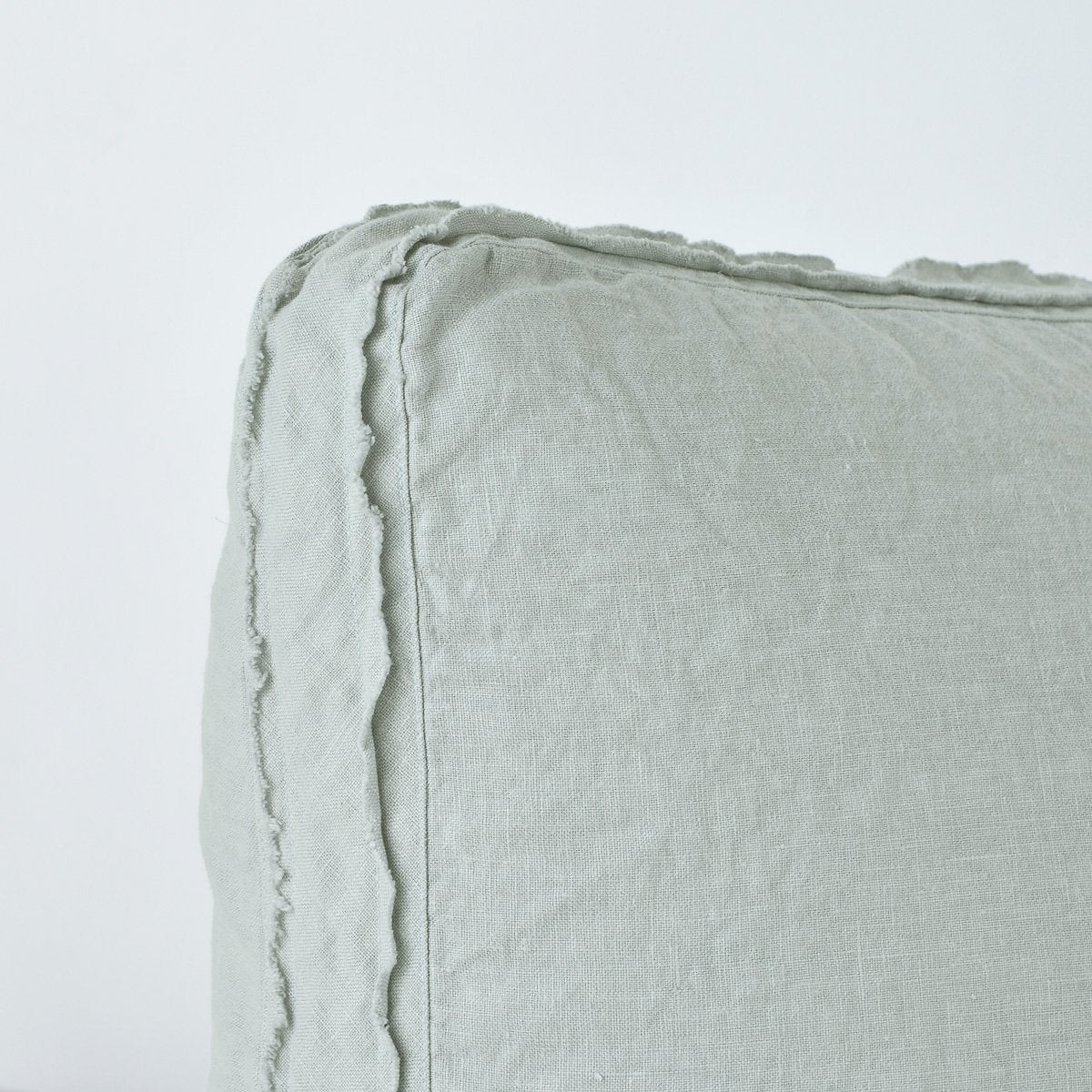 Eucalyptus: Close-up angle of the corner of an Austin sham, highlighting the raw edge trim on either side of the gusset.