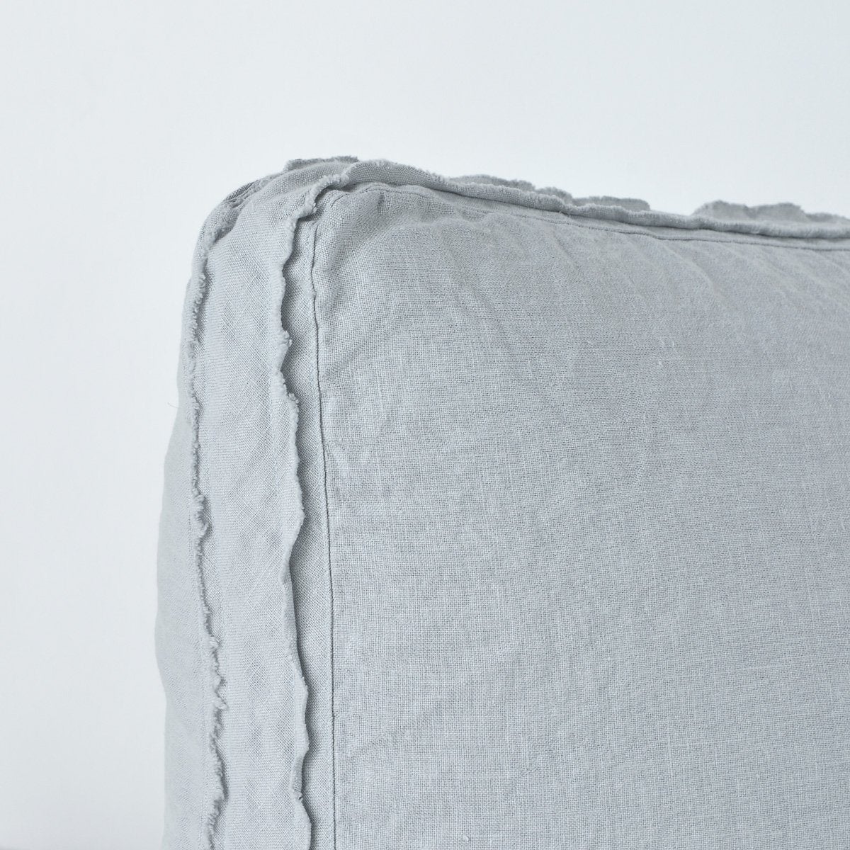 Mineral: Close-up angle of the corner of an Austin sham, highlighting the raw edge trim on either side of the gusset.