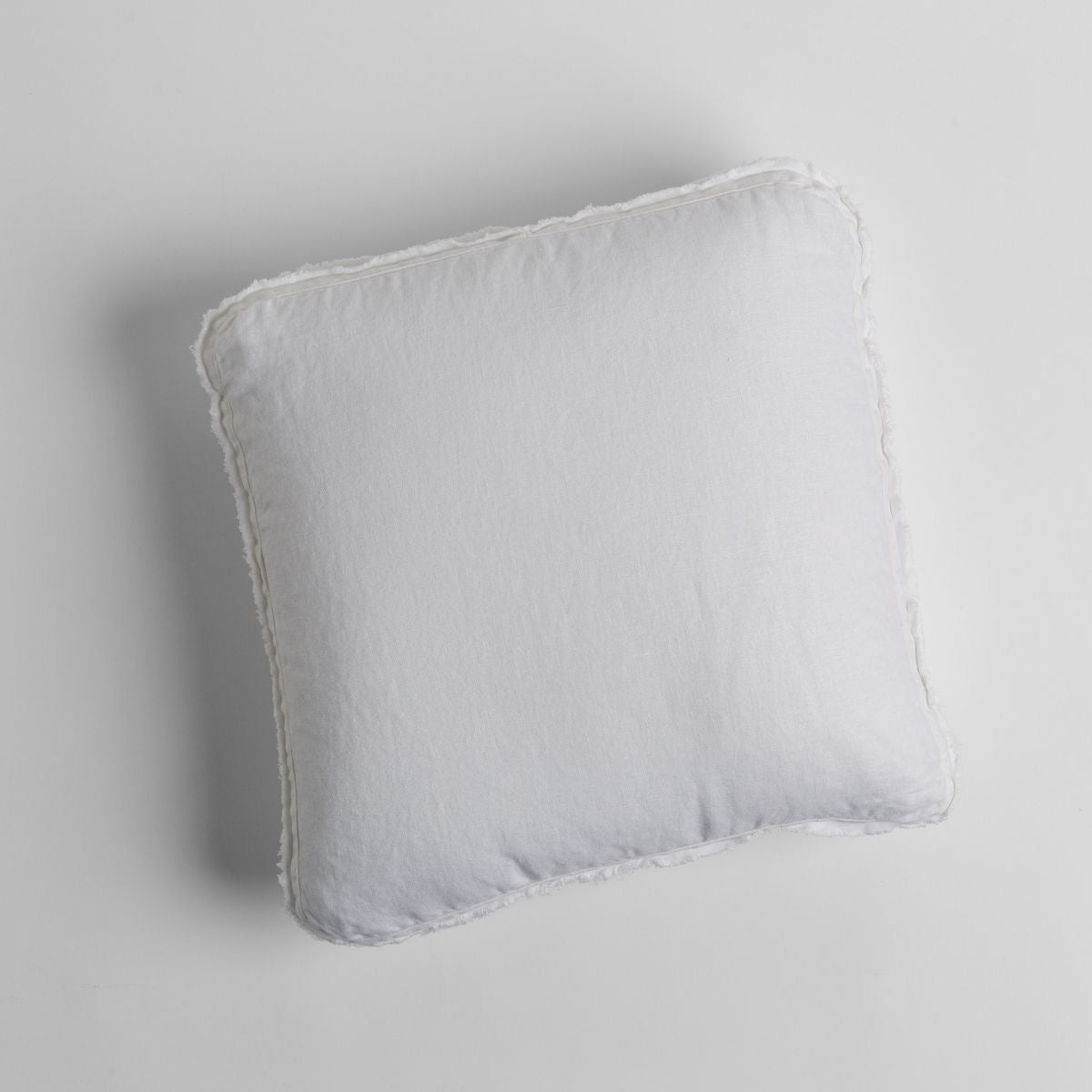 White: midweight linen 18x18 inch throw pillow shot from overhead against a white background. 