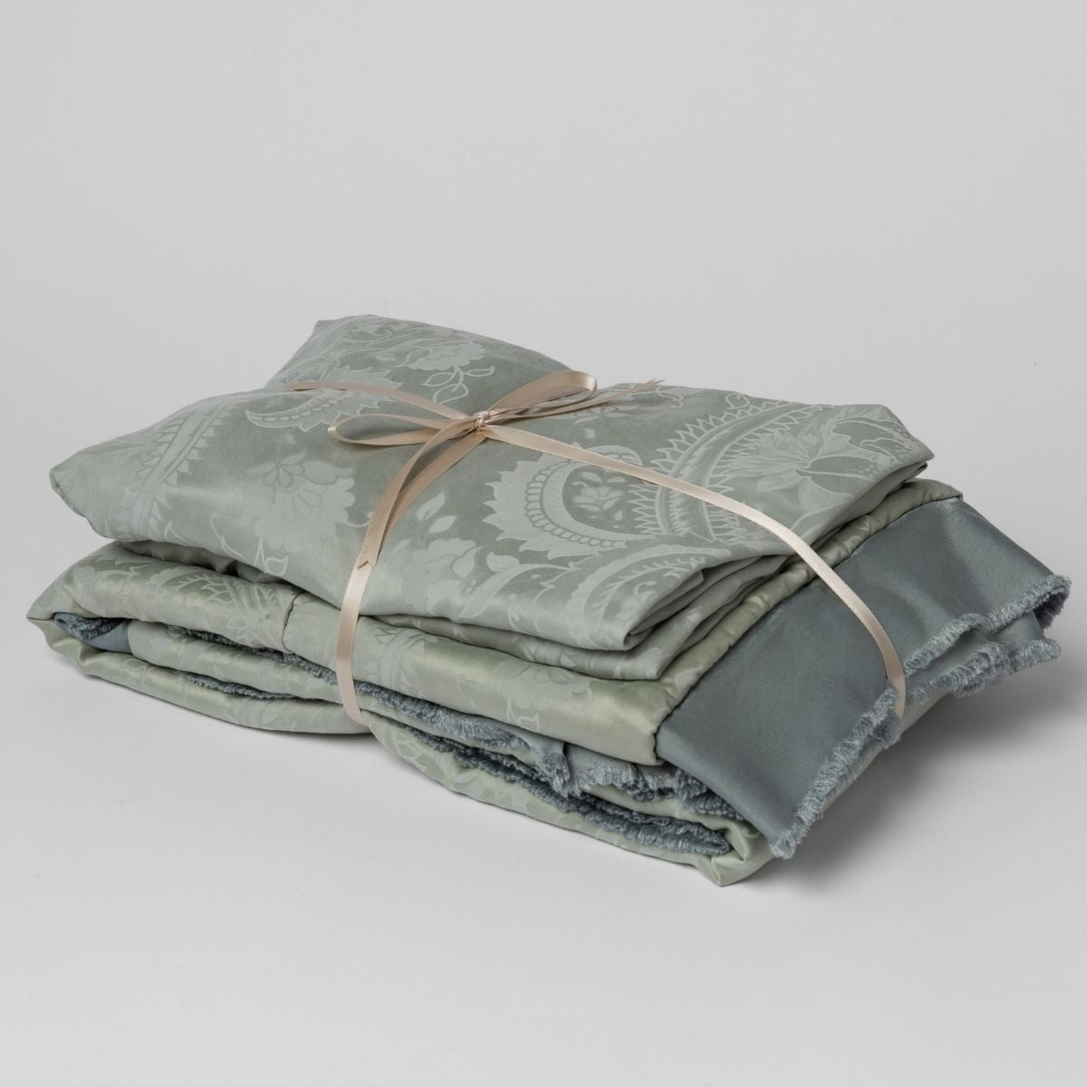 Mineral:  matching crib sheet and baby blanket bundled and tied with a ribbon against a white background.