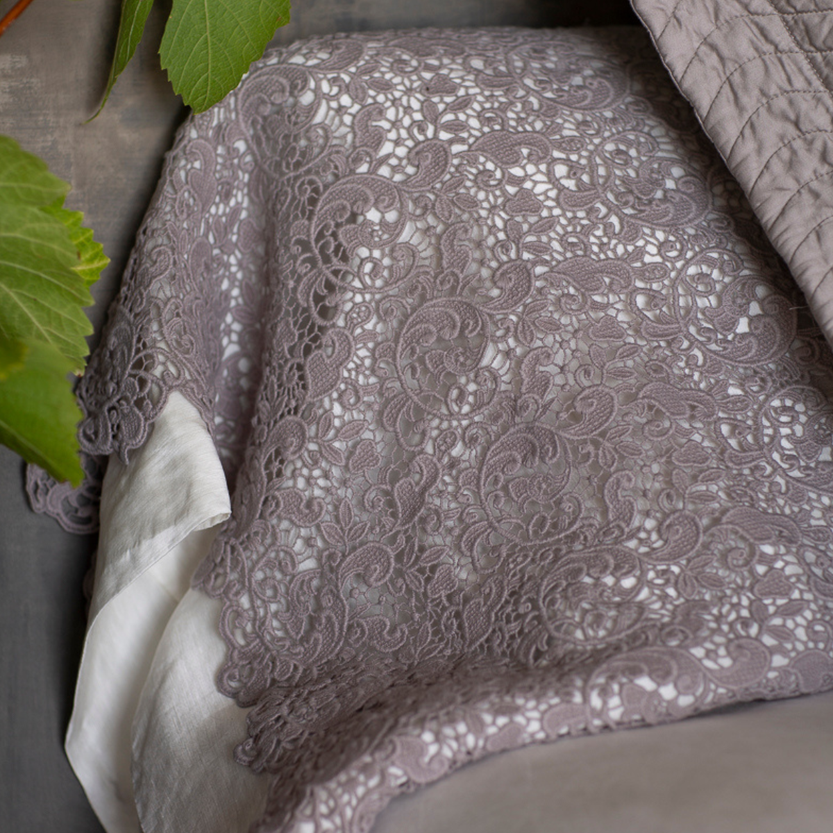 : a close up of the cotton lace pillowcase cover with winter white liner in silk tencel. 