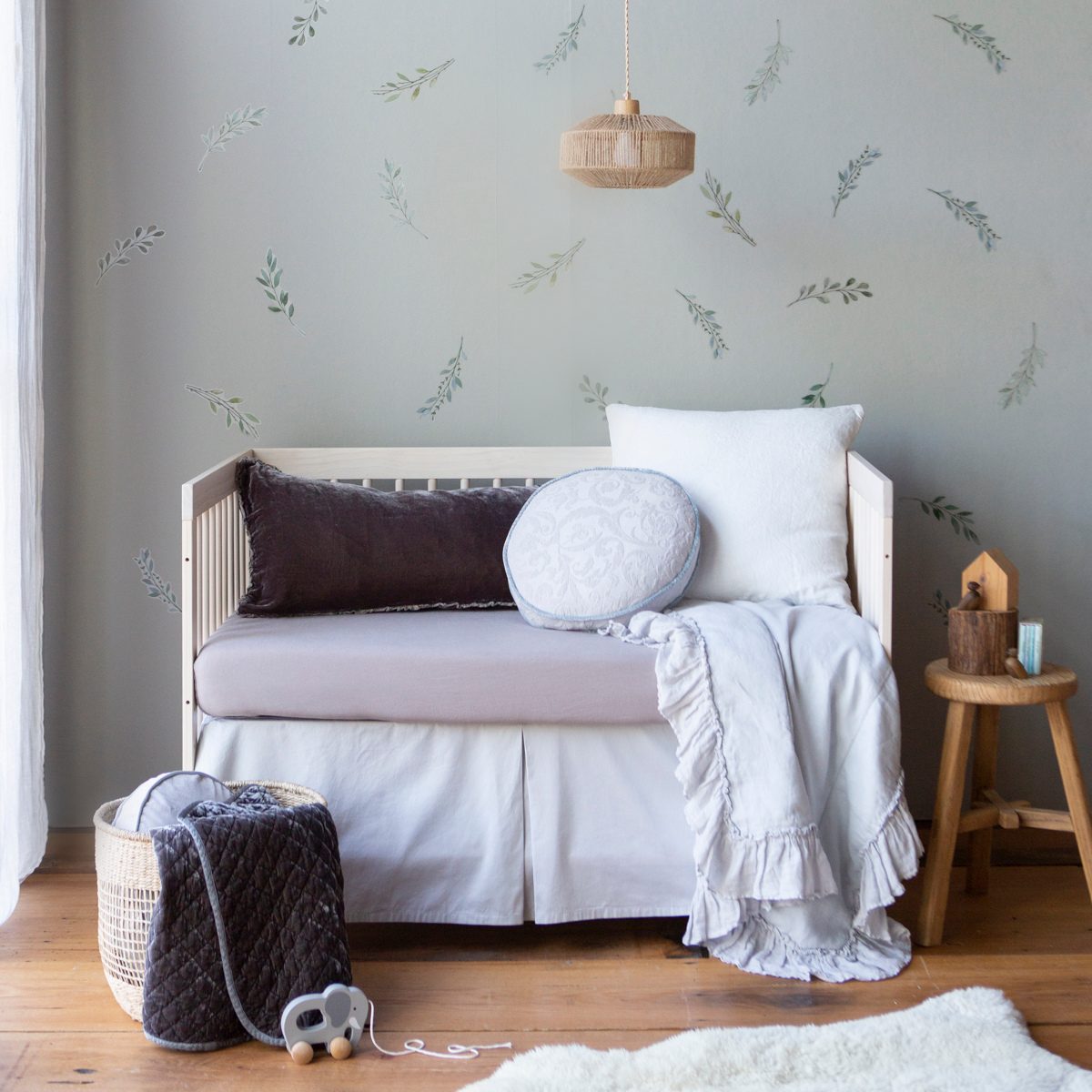 [allvariants]: Cotton sateen crib skirt in cloud shown on a crib in grey and light blue tones, highlighting the tailored, ungathered style.