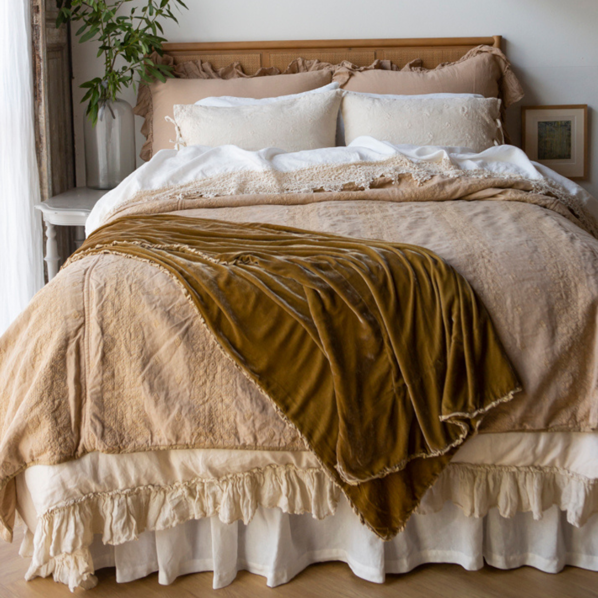 [allvariants]: A neutral toned bedroom all about texture, the embroidered bedspread is layered with rumpled linen, cotton lace, and gauzy ruffles.