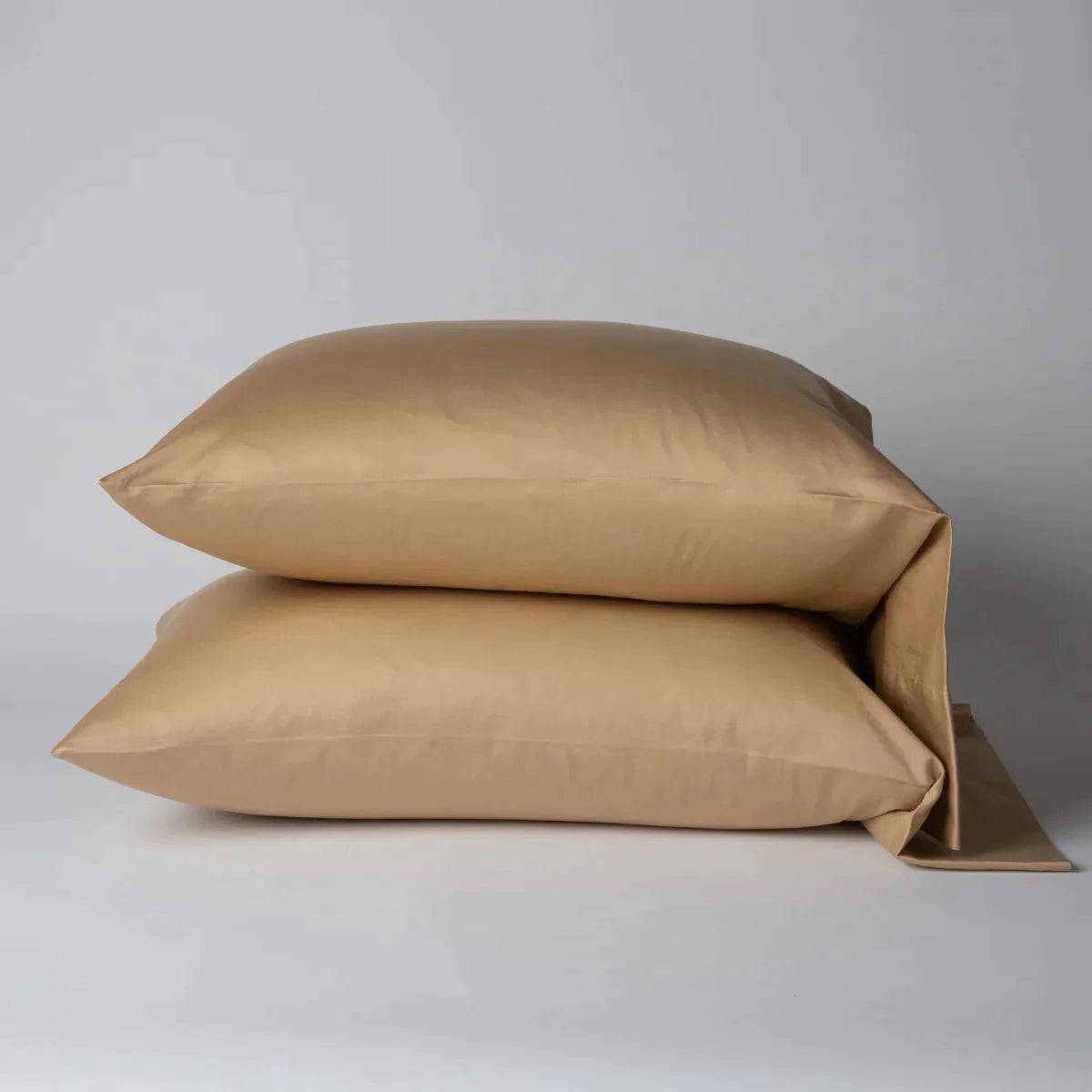 Honeycomb: Two cotton sateen sleeping pillows, stacked neatly against a white backdrop - side view.