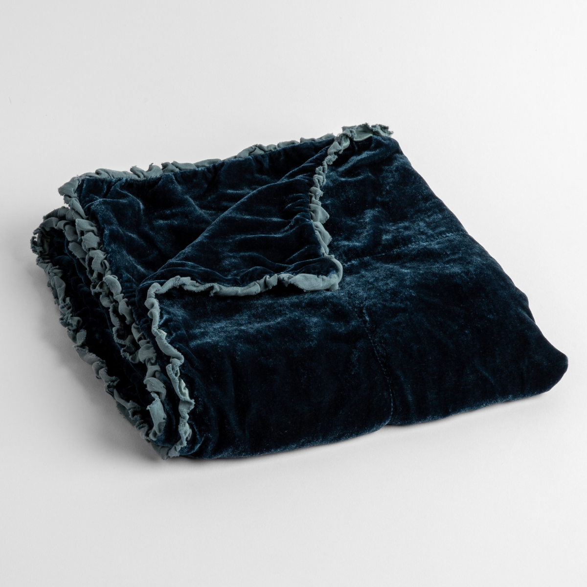 Cenote:  silk velvet baby blanket with charmeuse trim shown slightly overhead with a corner folded back to show trim detail against a white background. 