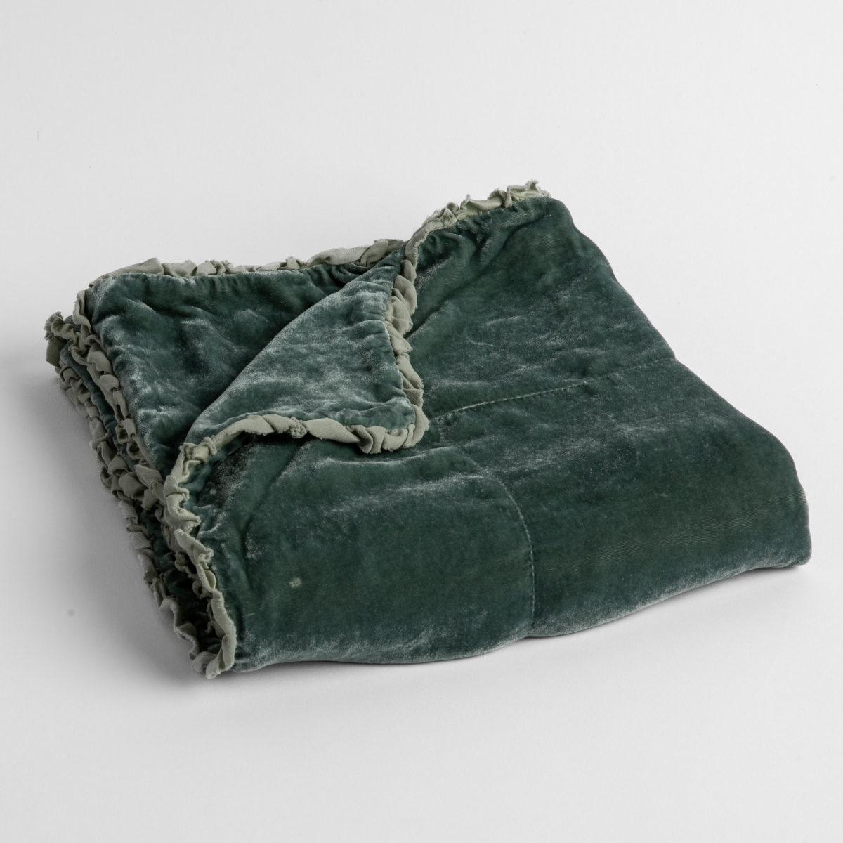 Eucalyptus:  silk velvet baby blanket with charmeuse trim shown slightly overhead with a corner folded back to show trim detail against a white background. 
