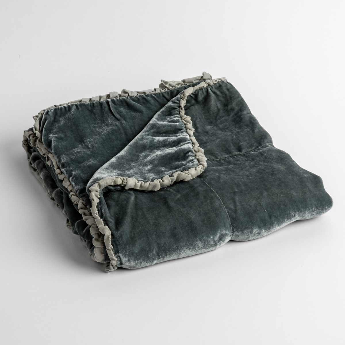 Mineral: silk velvet baby blanket with charmeuse trim shown slightly overhead with a corner folded back to show trim detail against a white background. 