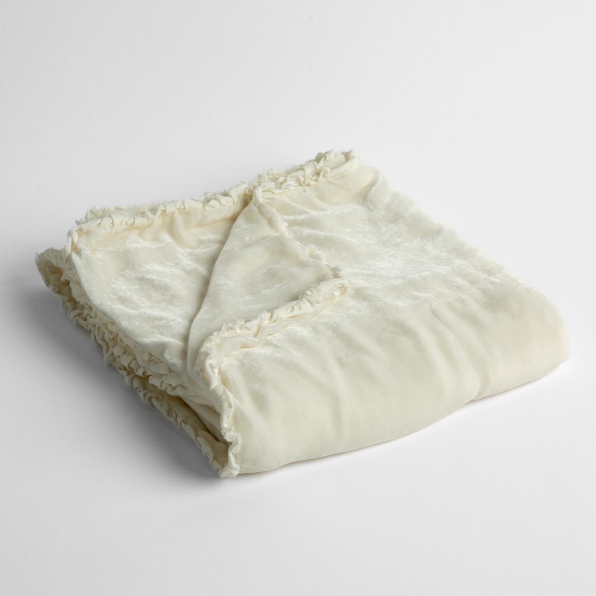 Winter White:  silk velvet baby blanket with charmeuse trim shown slightly overhead with a corner folded back to show trim detail against a white background. 