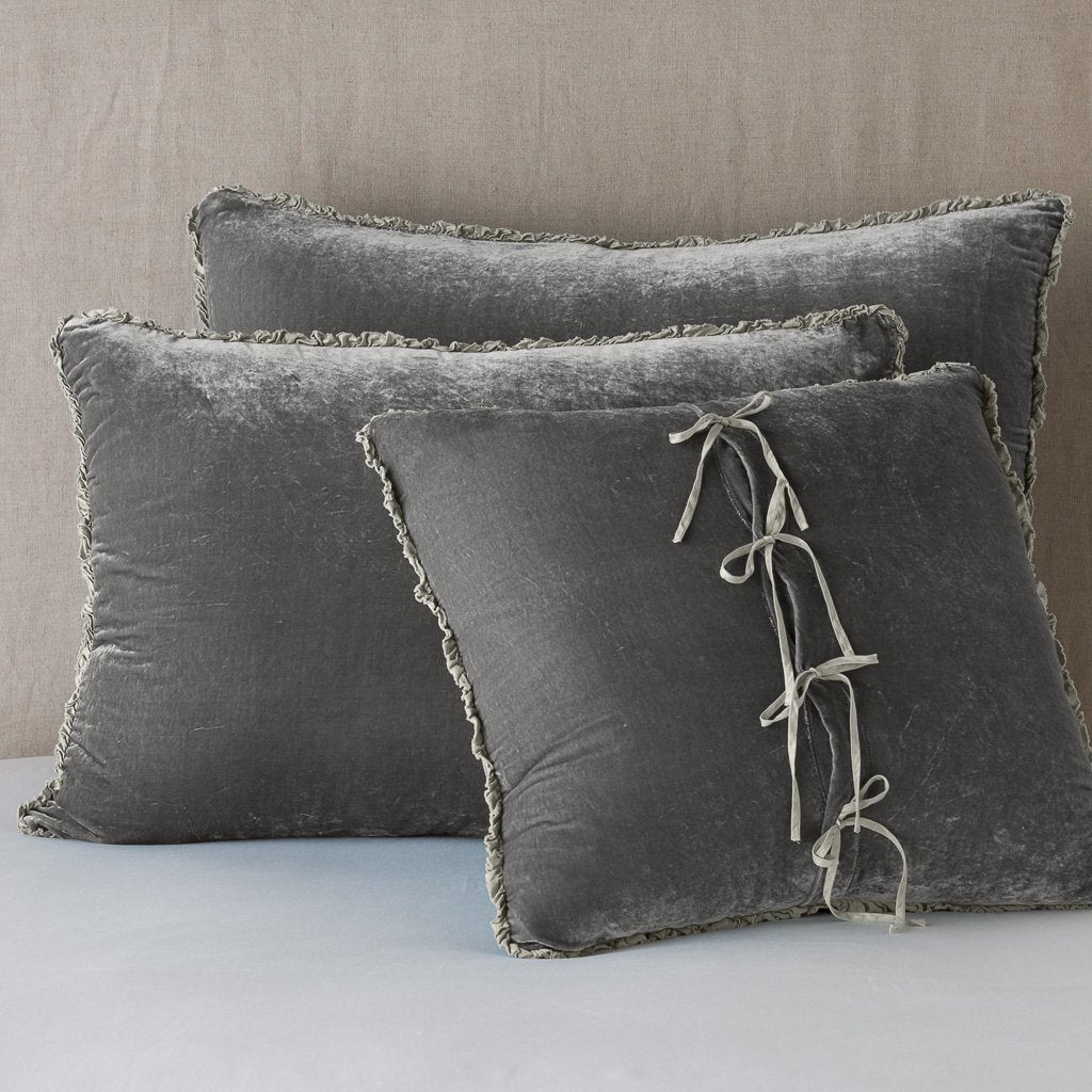 Fog: Silk velvet  shams with a petite ruffle leaning upright against a neutral headboard. The front sham is backwards, showcasing the charmeuse tie closures.