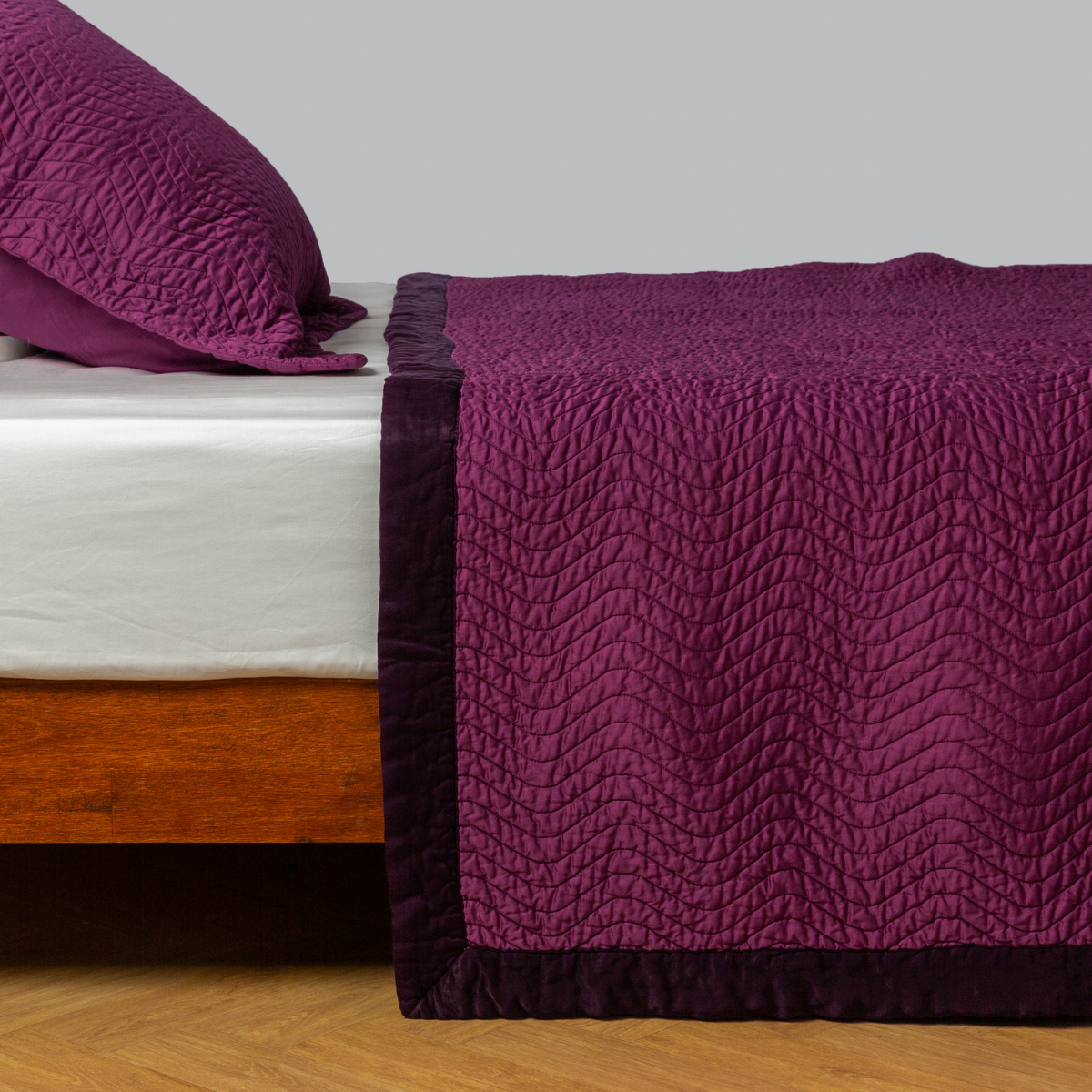 Fig: quilted cotton sateen coverlet with matching sham on a winter white fitted sheet - side view. 