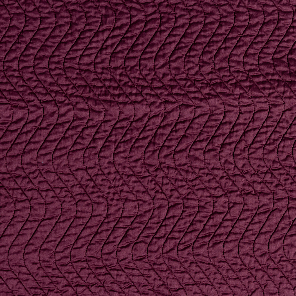 Fig: A close up of quilted cotton sateen fabric in fig, a richly saturated purple-garnet.