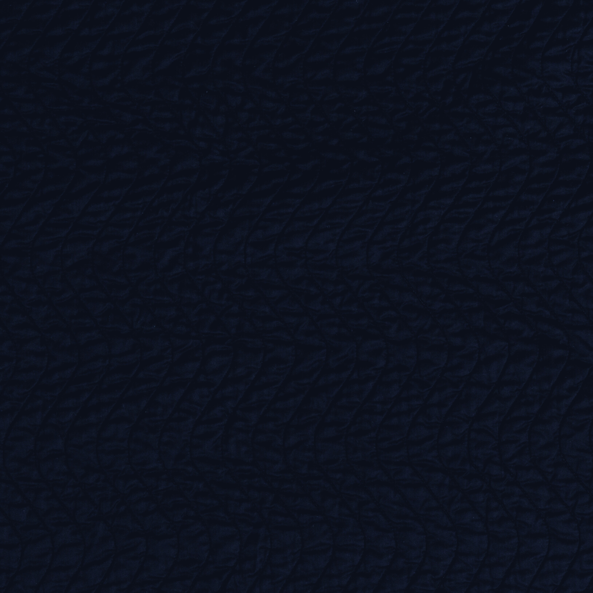 Corvino: A close up of quilted cotton sateen fabric in Corvino, a black tone.