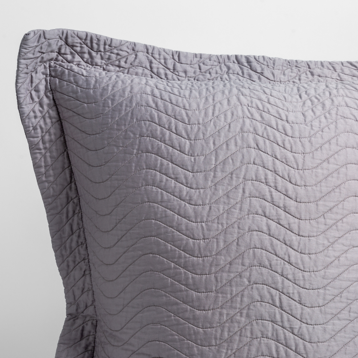 French Lavender: a close up of a pillow corner showing the flange framing quilted cotton sateen shot against a white background. 