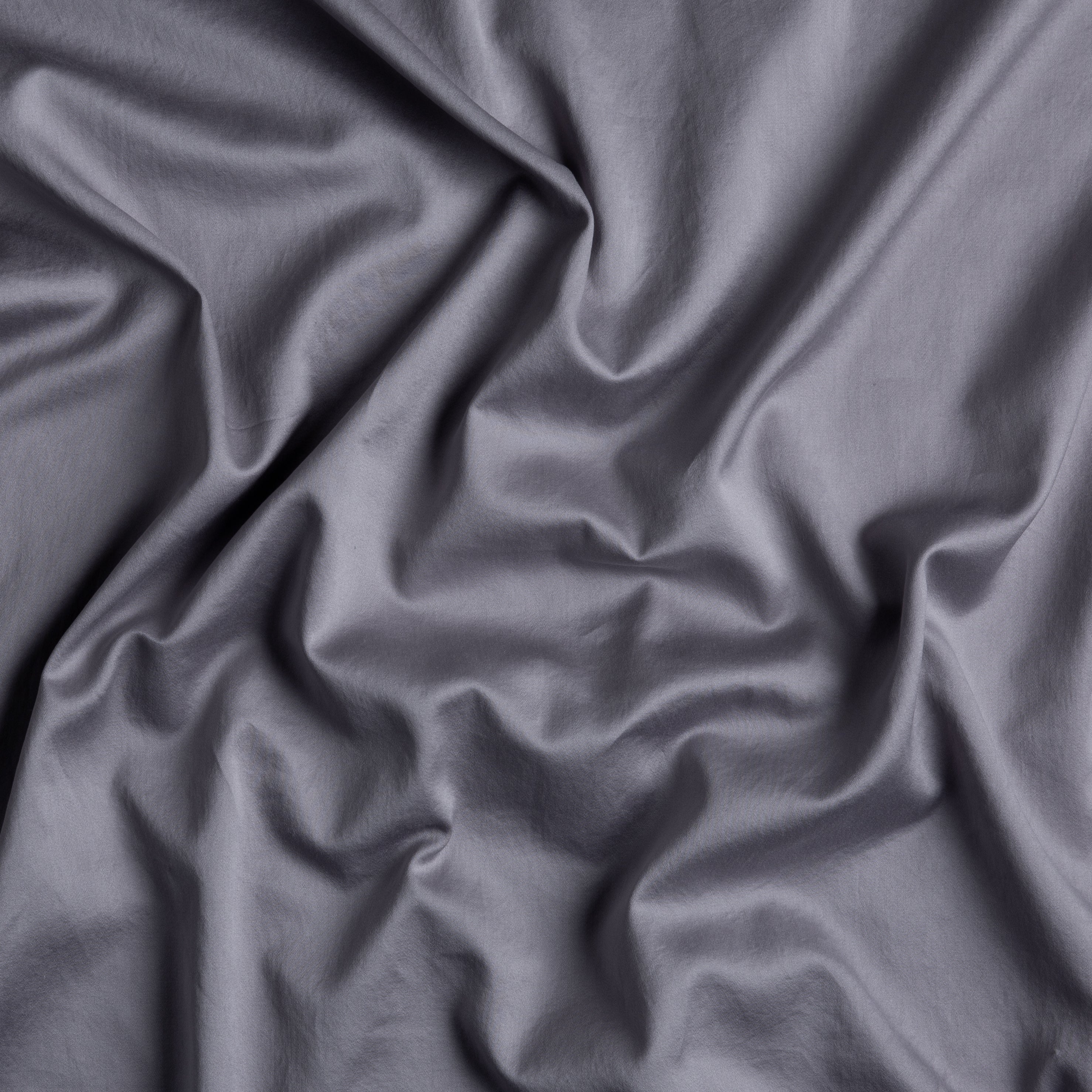 A close up of cotton sateen in french lavender, a neutral lavender tone; the fabric is gently rumpled. 