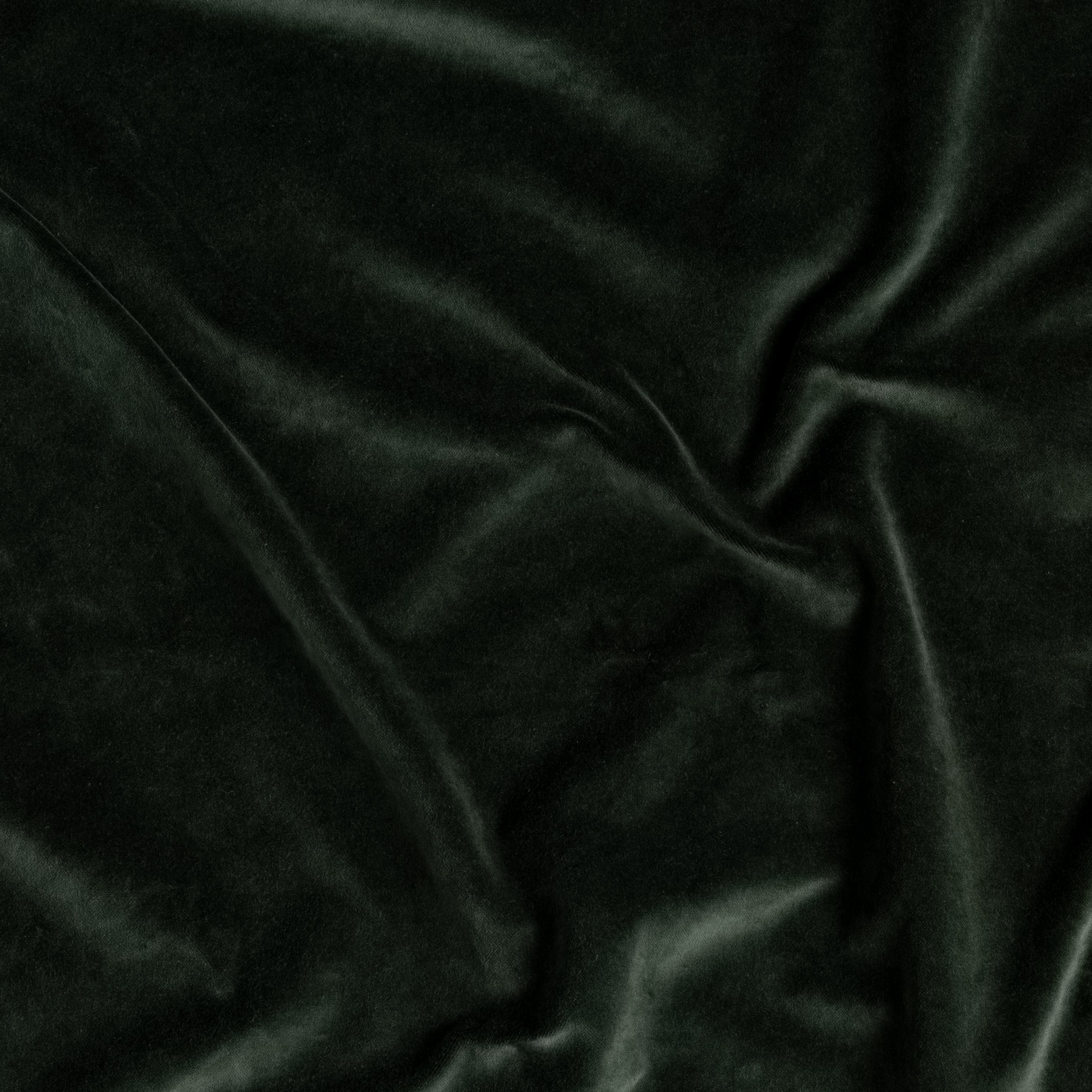 A close up of cotton velvet gently rumpled in Juniper, a dark green tone. 