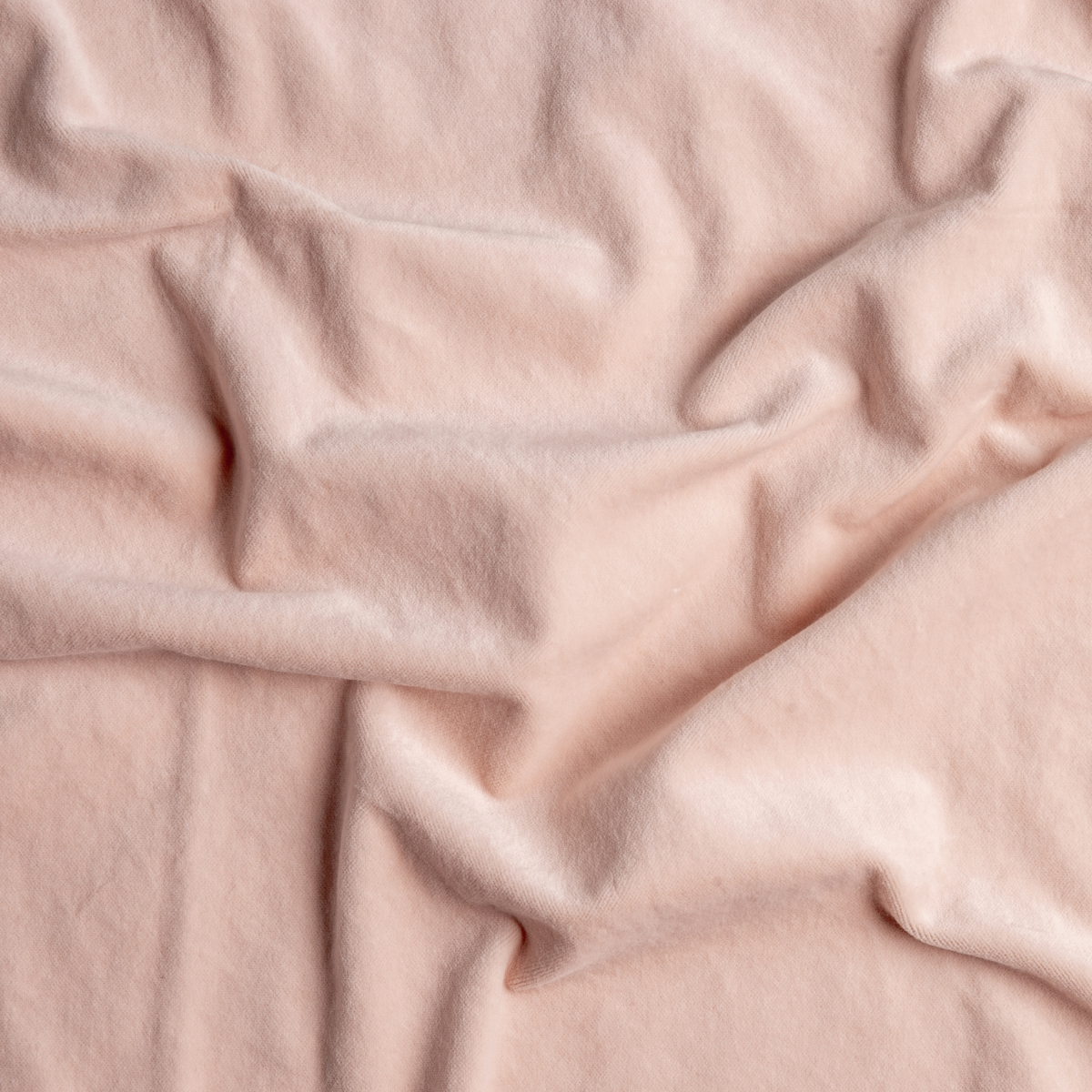Pearl: A close up of cotton velvet fabric in pearl, a nude-like, soft rose pink tone.