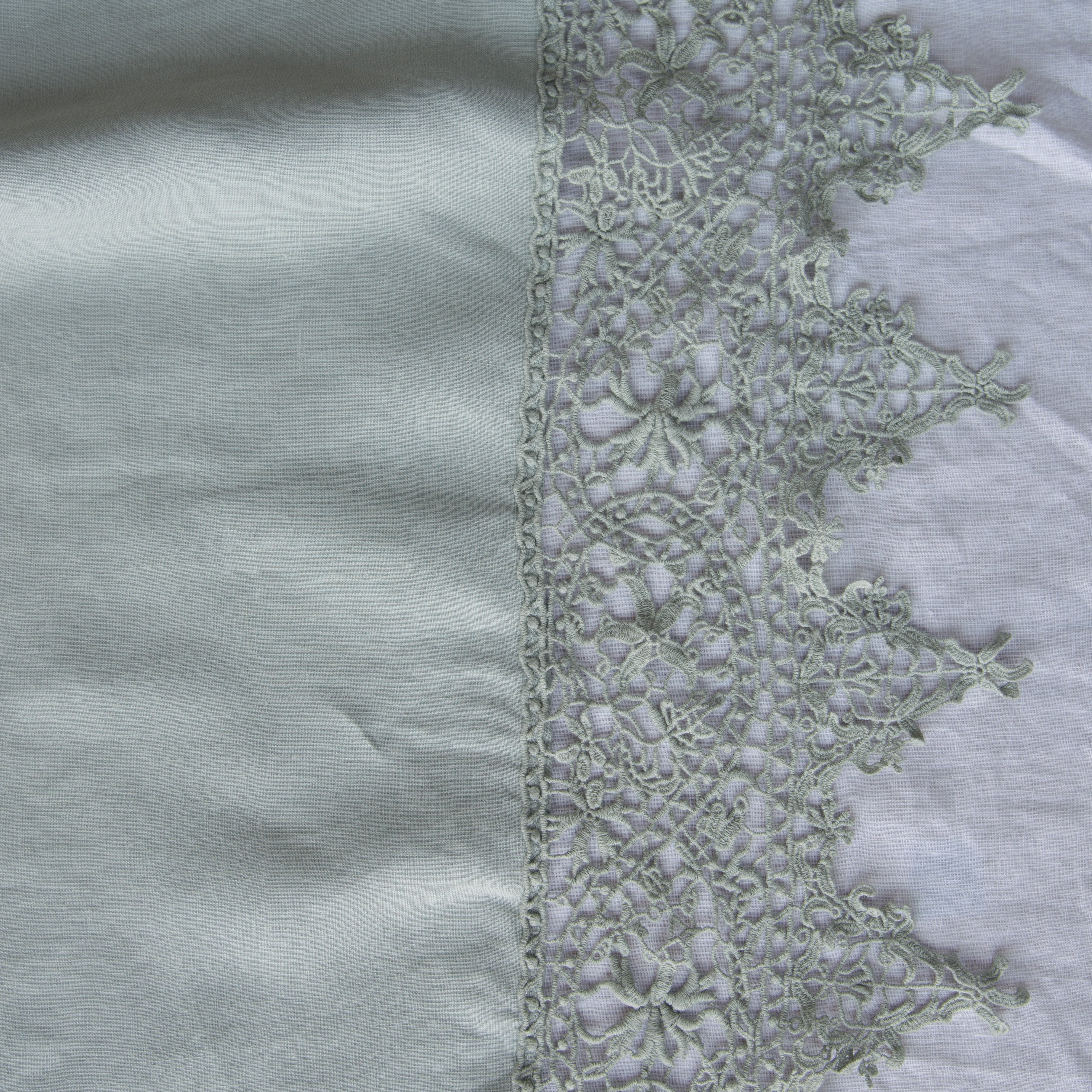 Eucalyptus: A close up of Frida, an antique cotton lace trim on a linen body, shown in eucalyptus, a soft light green.
