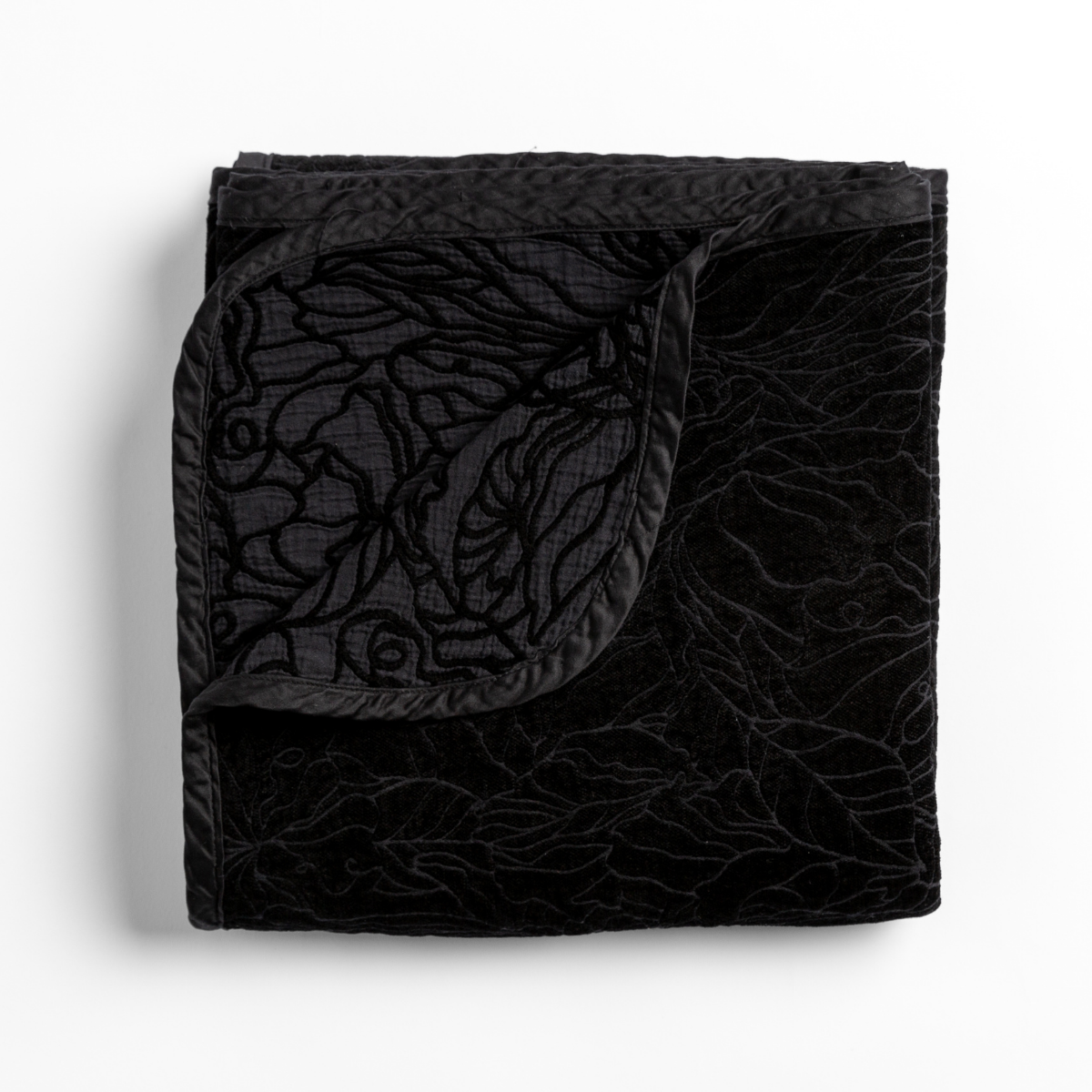 Corvino: folded blanket with its cotton jacquard side visible on the corner foldback against the chenille jacquard side. 