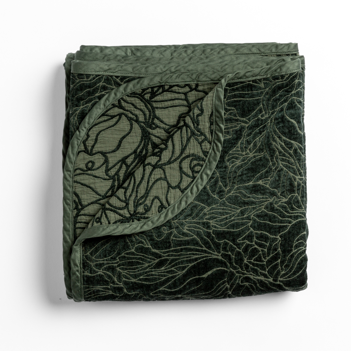 Juniper: folded blanket with its cotton jacquard side visible on the corner foldback against the chenille jacquard side. 