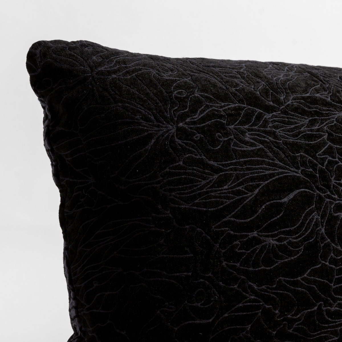 Corvino: close up of the chenille jacquard corner of a pillow cushion with a single-line floral pattern.