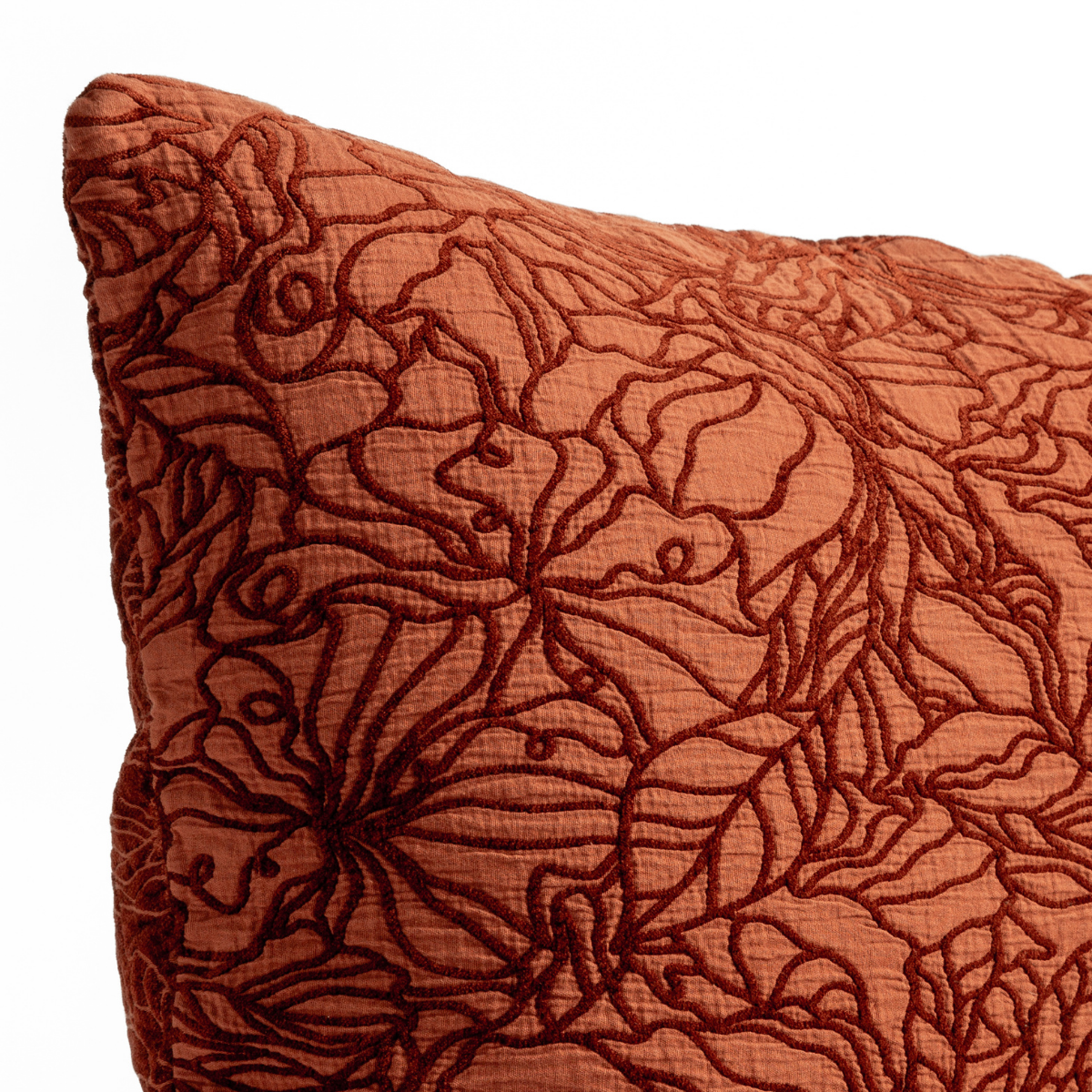 Autumn: A close-up of the corner of a Georgia Throw Pillow with the cotton jacquard side in Autumn, a rich terracotta tone, shown against a white background.