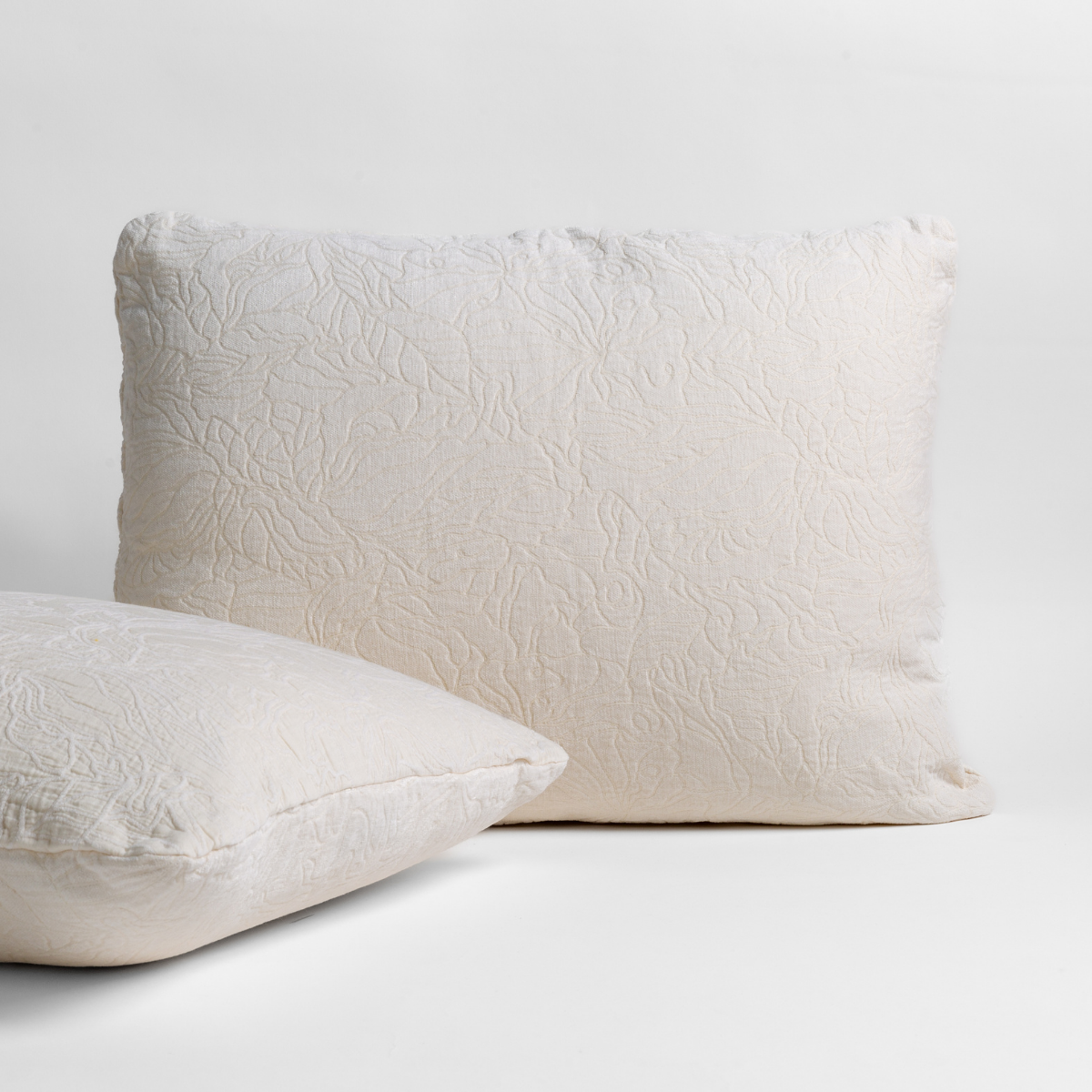 Winter White: pair of shams shown against a white background show the chenille and cotton jacquard faces and floral motif. 