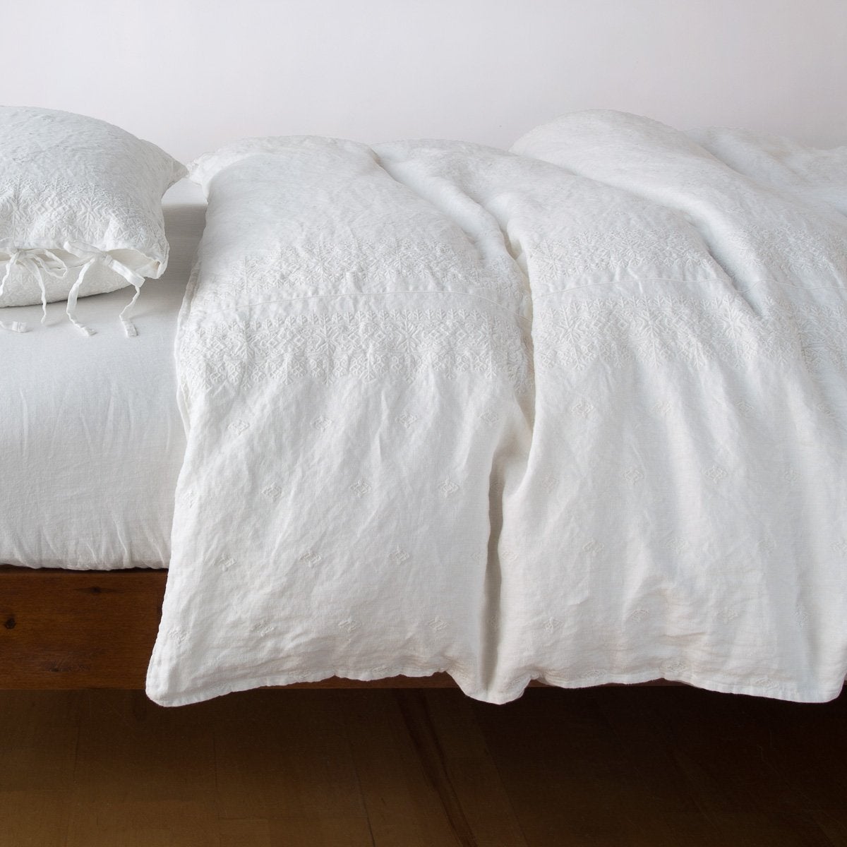 [allvariants]: Ines duvet cover in winter white, lightly rumpled on a monochromatic bed against a plain background - side view.