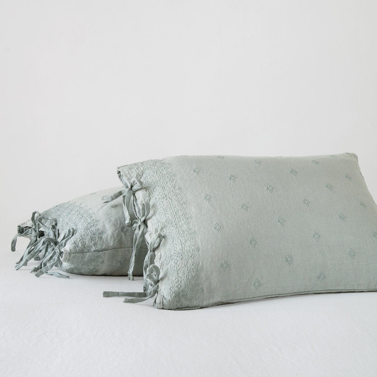 Eucalyptus: standard sham leaning against a king sham, on a white background and at a slight angle to showcase the linen side-tie closure.