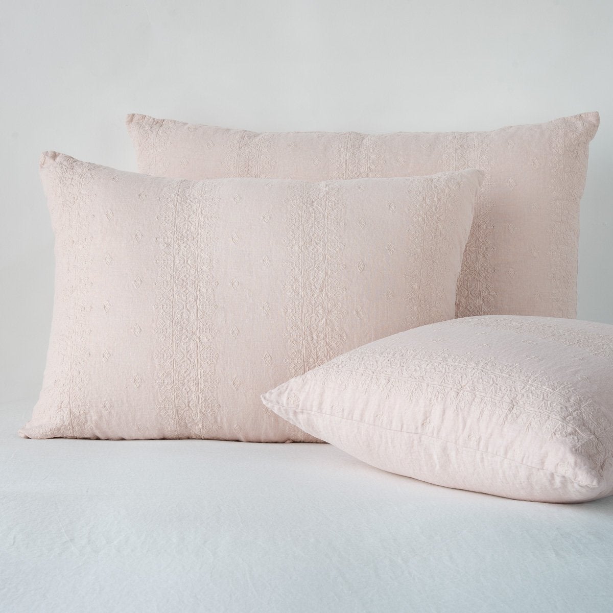 Pearl: two shams leaning upright and one laying flat at an angle, against a white background.