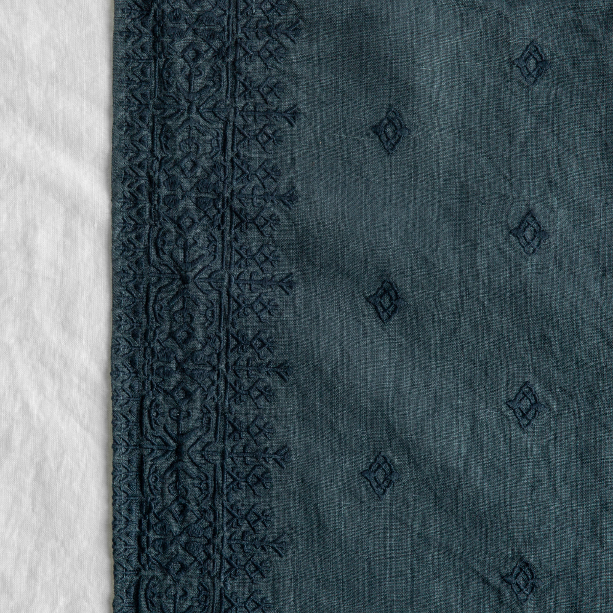 Midnight: A close up of Ines, midweight linen with cotton embroidery, in white.