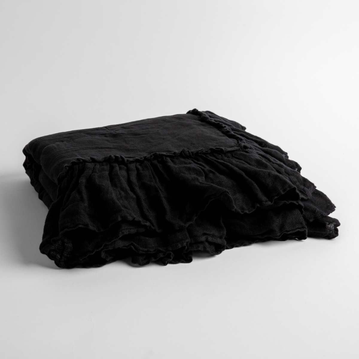 Corvino:   a folded linen with linen whisper ruffled blanket folded and positioned to show the ruffle detail against a white background and slightly overhead. 