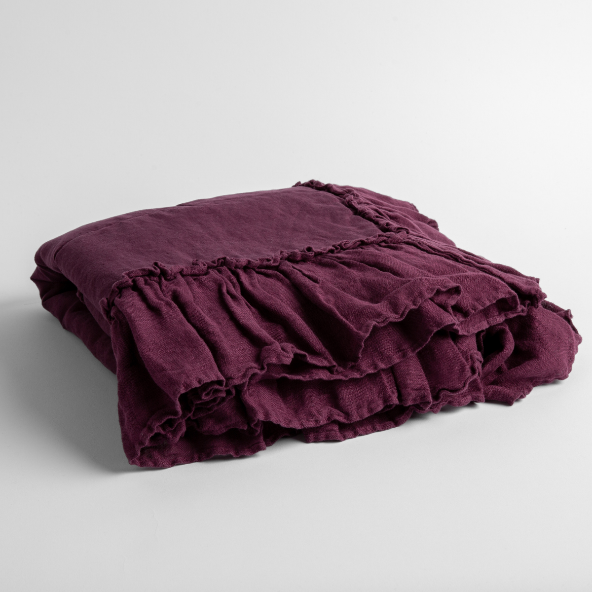 Fig:  a folded linen with linen whisper ruffled blanket folded and positioned to show the ruffle detail against a white background and slightly overhead. 