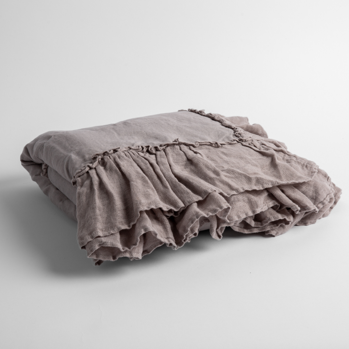 Moonlight:   a folded linen with linen whisper ruffled blanket folded and positioned to show the ruffle detail against a white background and slightly overhead. 