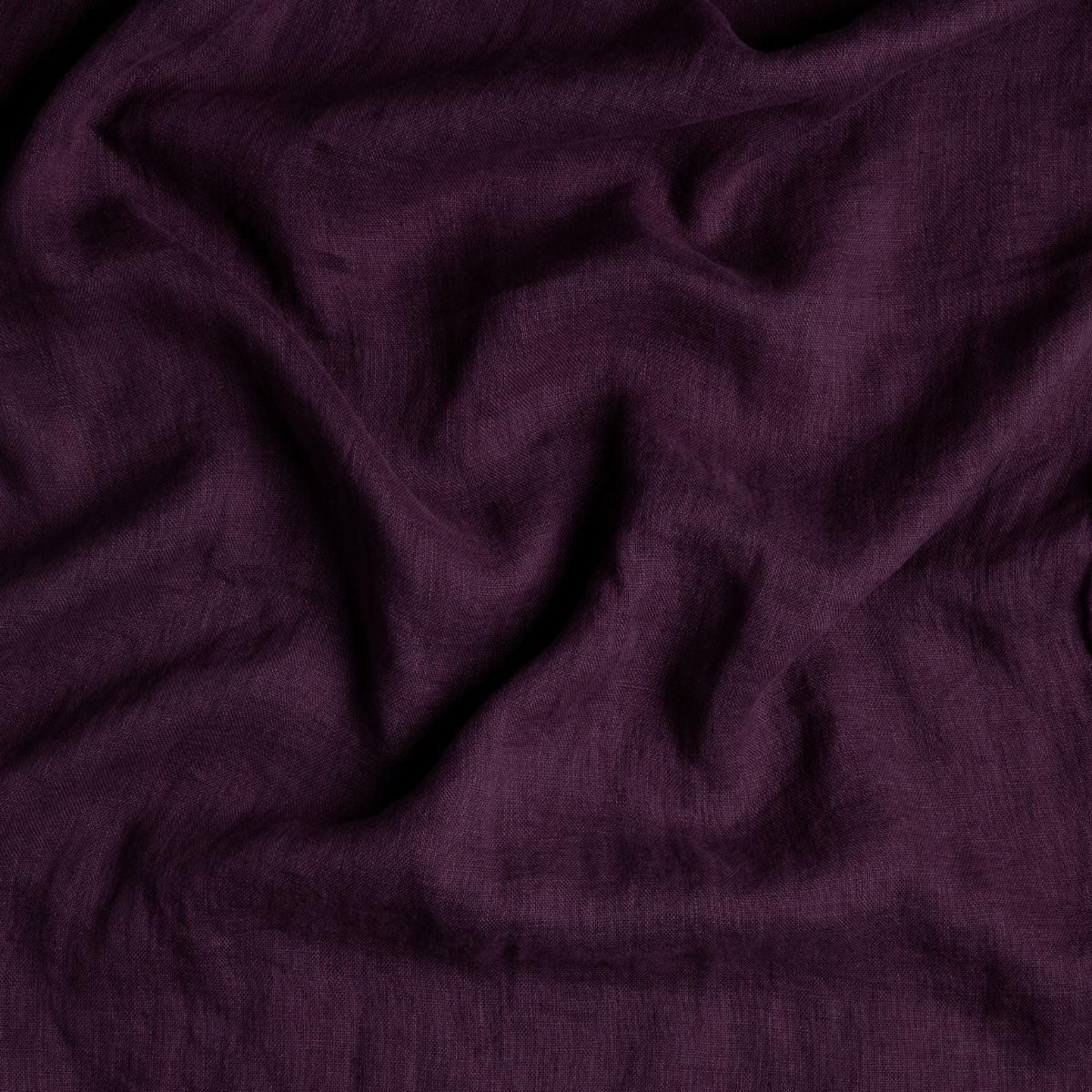 Fig: A close up of linen whisper fabric in fig, a richly saturated purple-garnet.