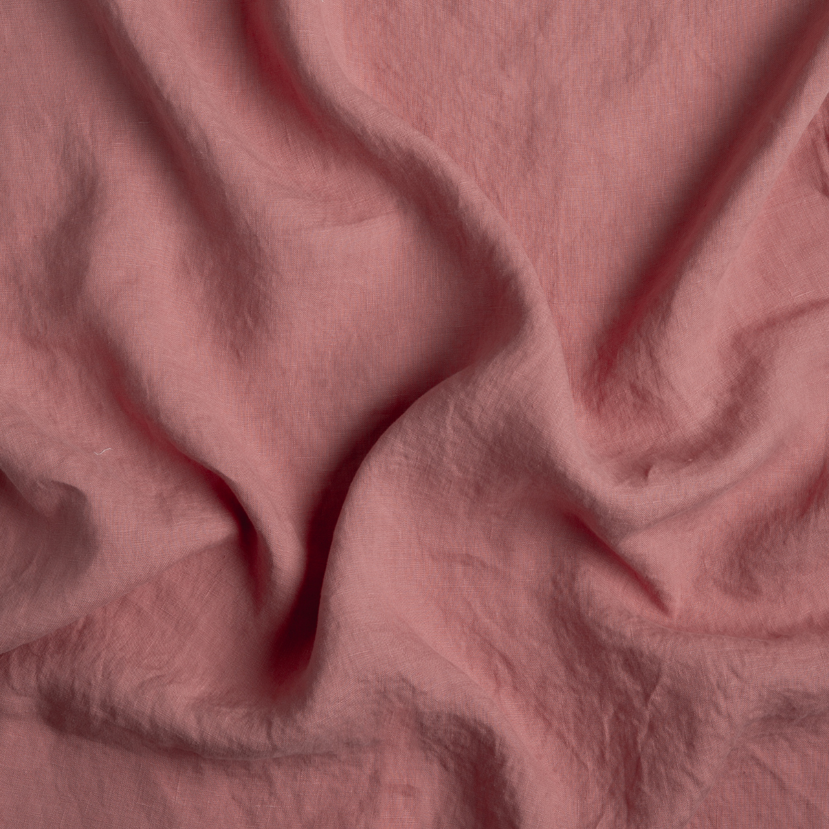 Poppy: A close up of linen fabric in poppy, a warm coral pink.